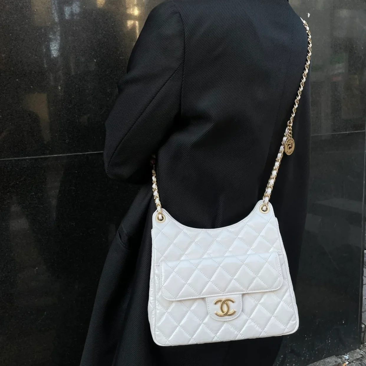 Коллекция Chanel ?Ранняя весна 2023? — сумка-хобо в стиле хиппи — маленькая — белая — фотографии в одежде.