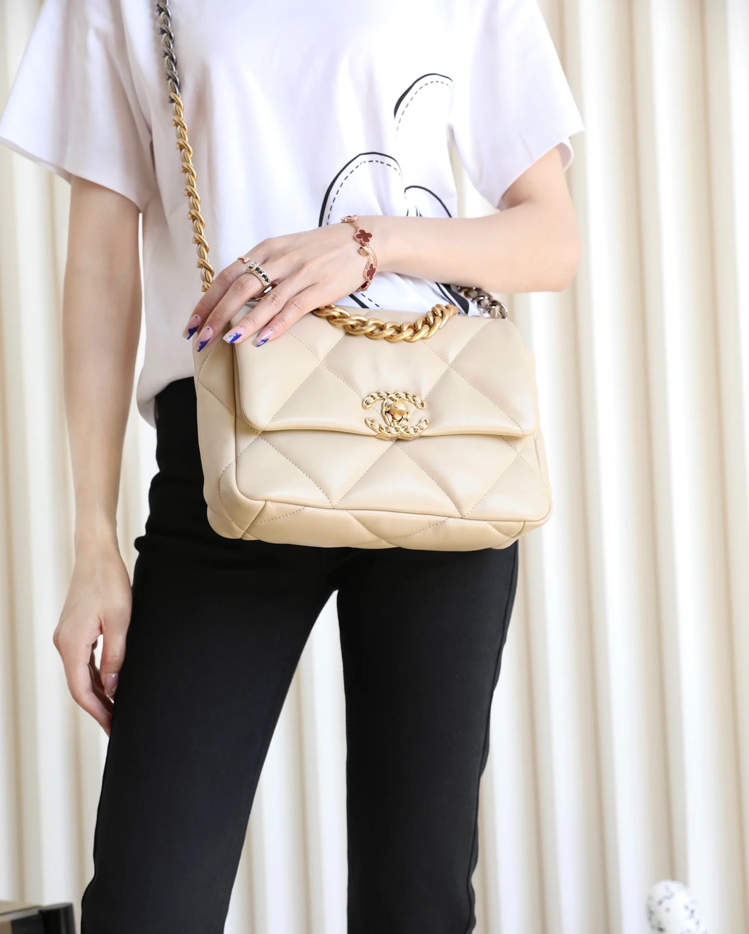 Сумка Chanel 19 — абрикосового цвета с золотой фурнитурой — маленькая — на фото в одежде.