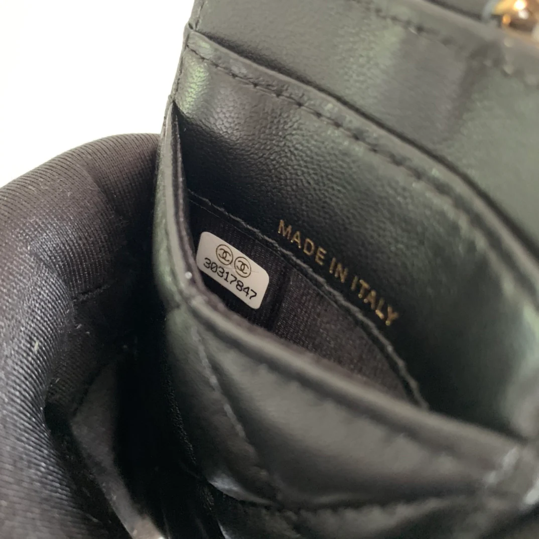 Держатель для удостоверений личности Chanel — из черной овечьей кожи с золотой пряжкой.