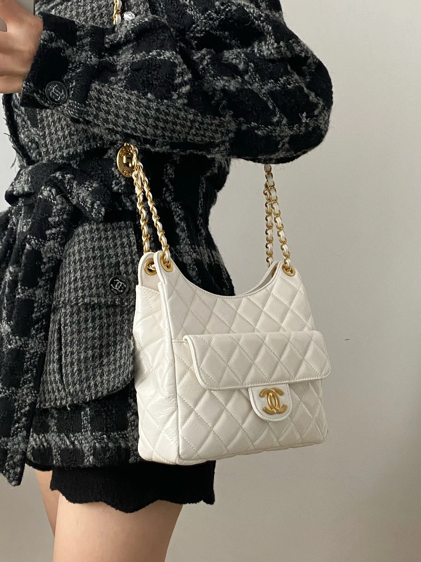 Коллекция Chanel ?Ранняя весна 2023? — сумка-хобо в стиле хиппи — маленькая — белая — фотографии в одежде.