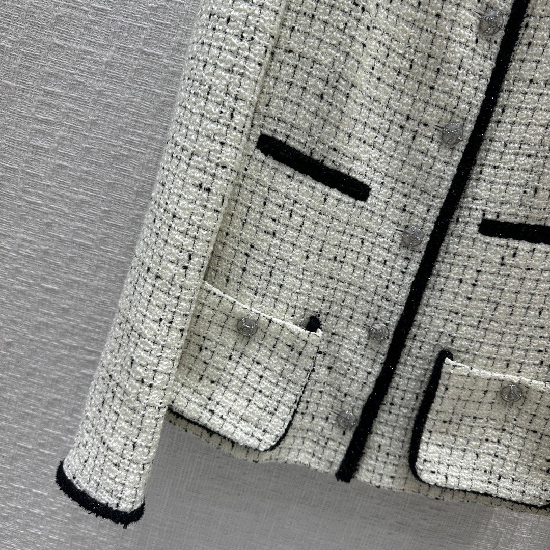 Chanel 2403 - Короткий жакет с изящной черной отделкой и блестящими деталями.