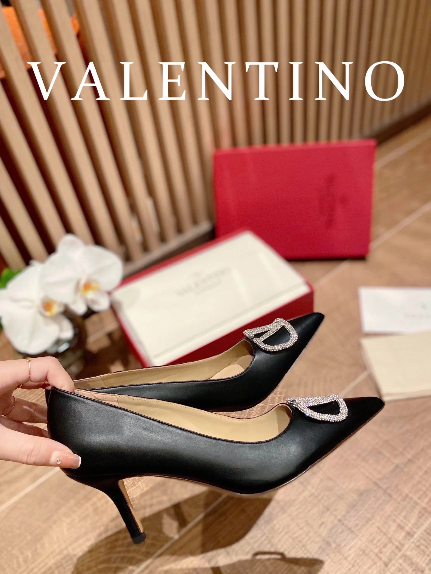 Туфли Valentino на каблуке с V-образным вырезом и бриллиантовой пряжкой — черные.