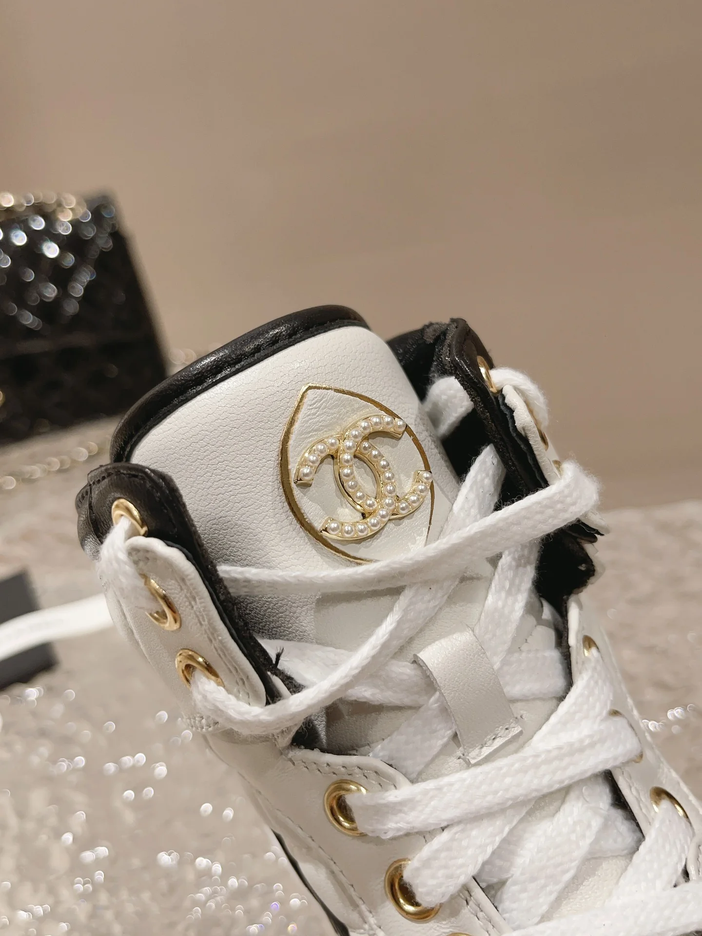 Высокие кроссовки Chanel — белые с перламутровыми вставками.