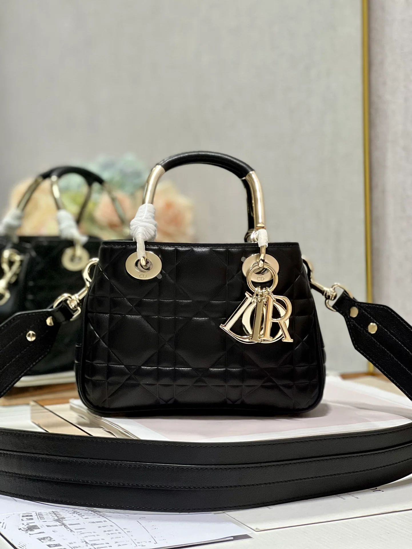 Сумочка Dior Lady 95 22, маленькая, черная с золотой фурнитурой.