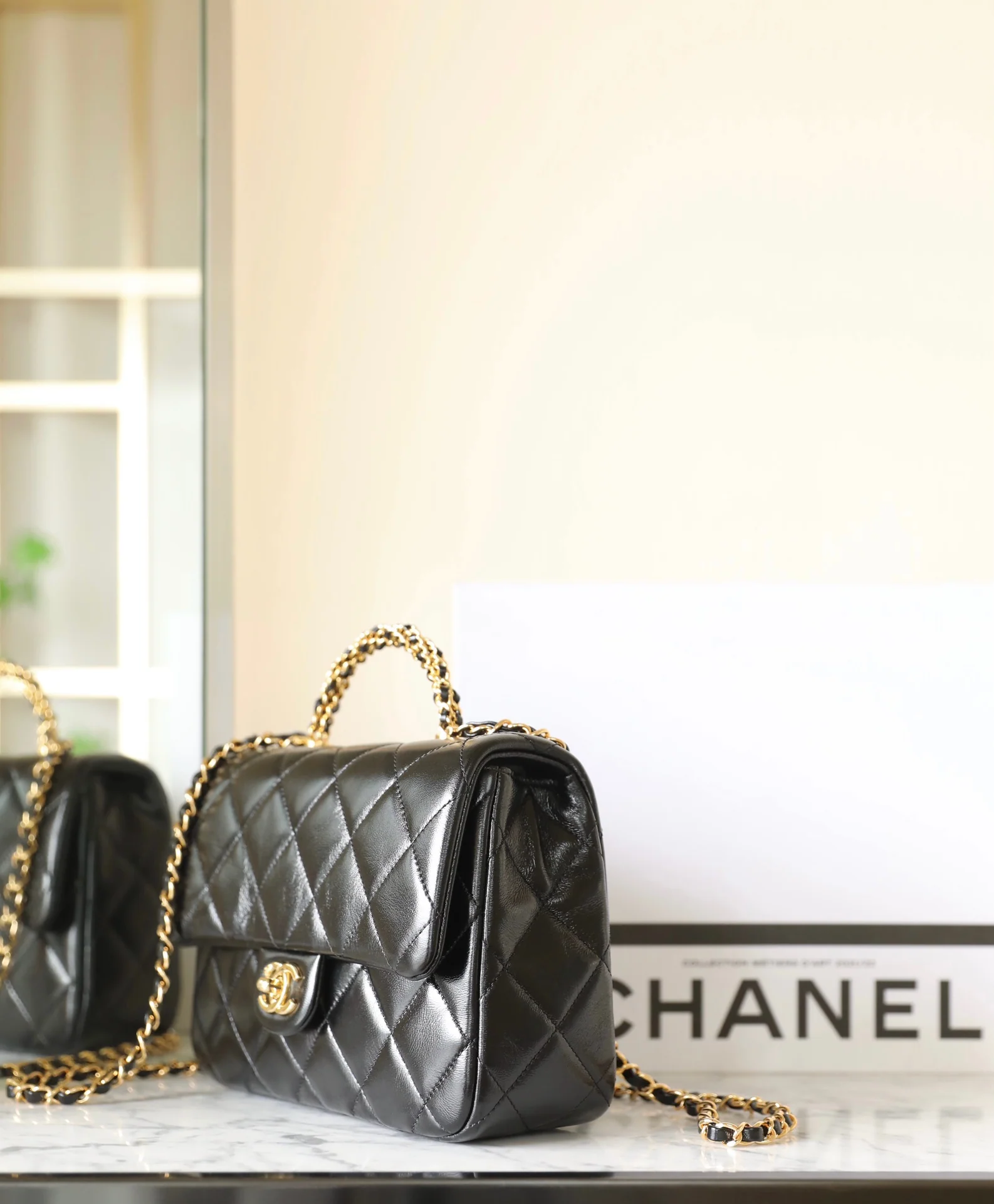 Большая черная сумка Chanel с клапаном и поворотной ручкой.