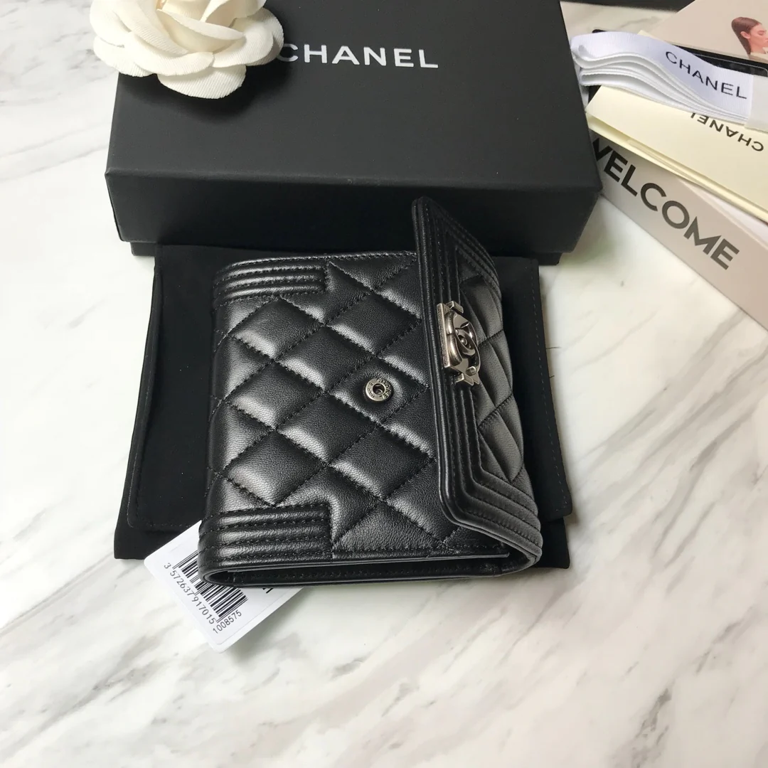 Кошелек Chanel Le Boy Tri-fold Wallet — из черной овечьей кожи с серебряной пряжкой.