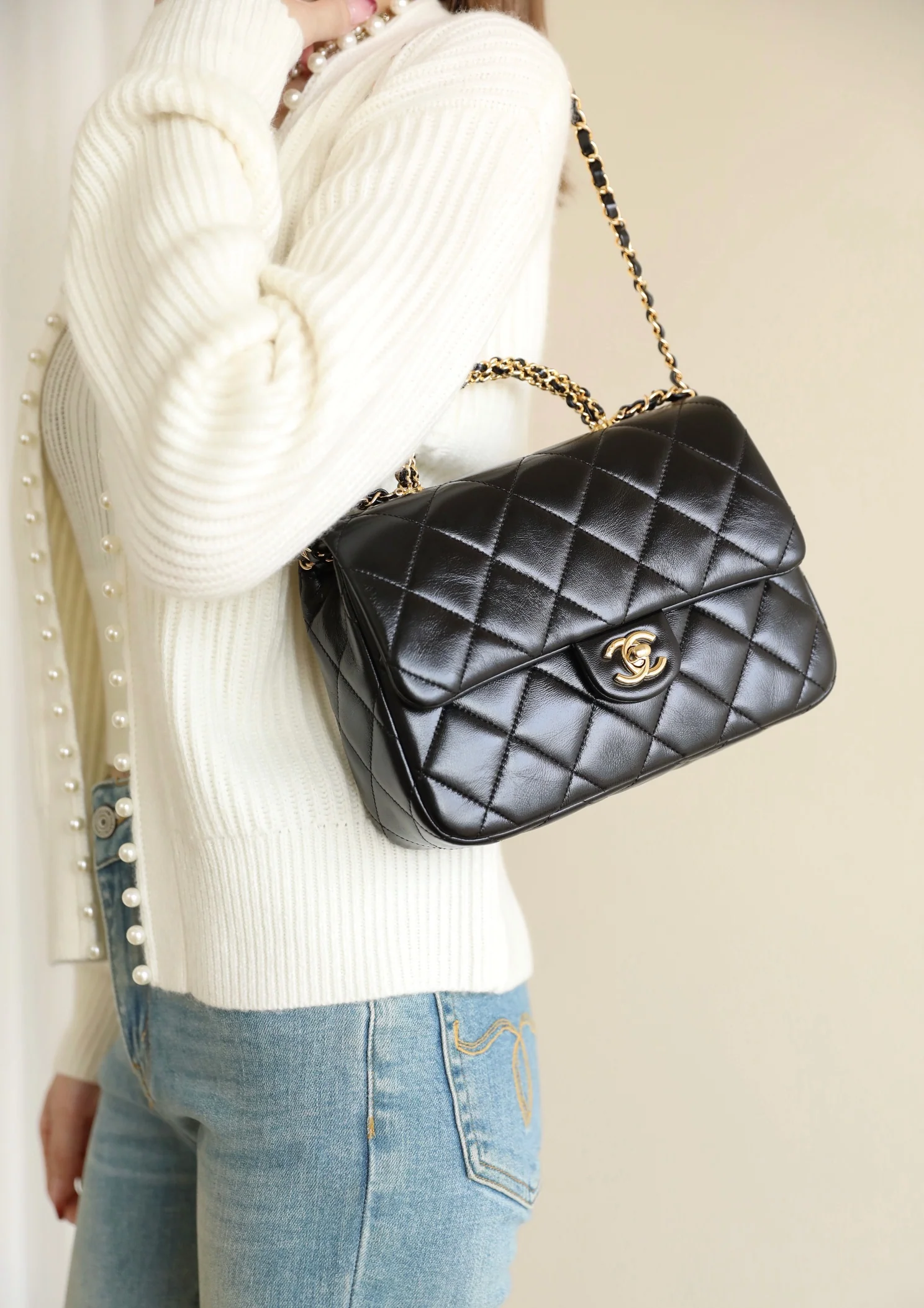 Большая черная сумка Chanel с клапаном и поворотной ручкой.