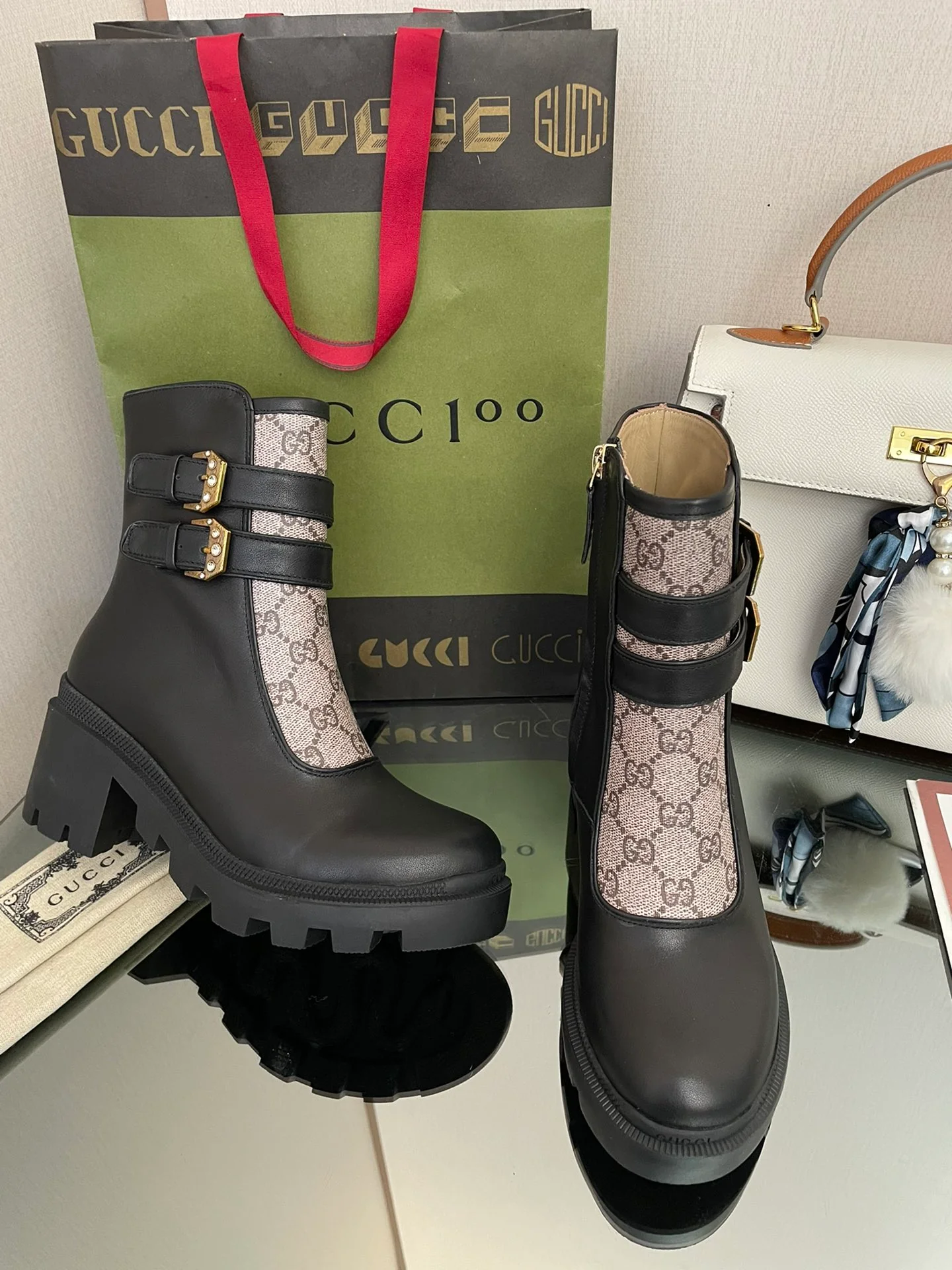 Сапоги Gucci на массивном каблуке до середины икры с монограммой — черные и бежевые.