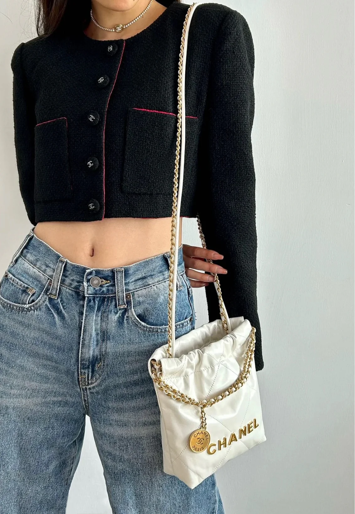 Мини-сумочка Chanel 22bag белого цвета с золотой фурнитурой.