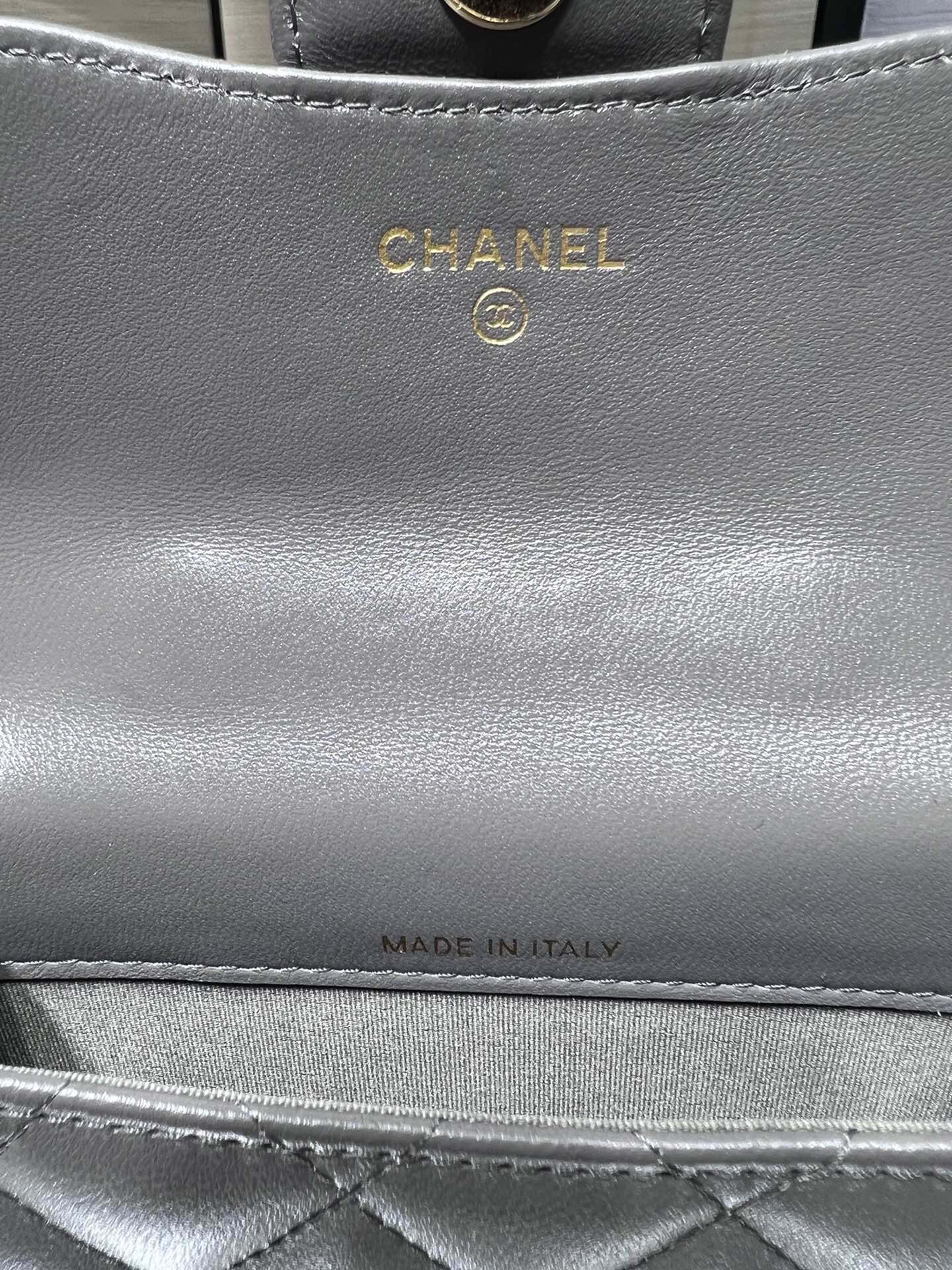 Сумка Chanel из коллекции Métiers d'Art 2022 года — маленькая сумка с цепочкой и ручкой — серая.