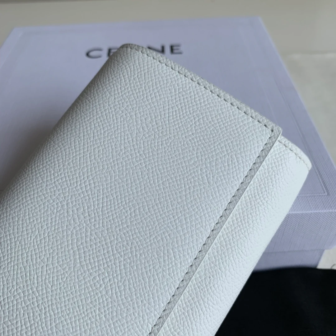 Кошелек-книжка Celine - кремовый с принтом в виде пальмовых листьев.