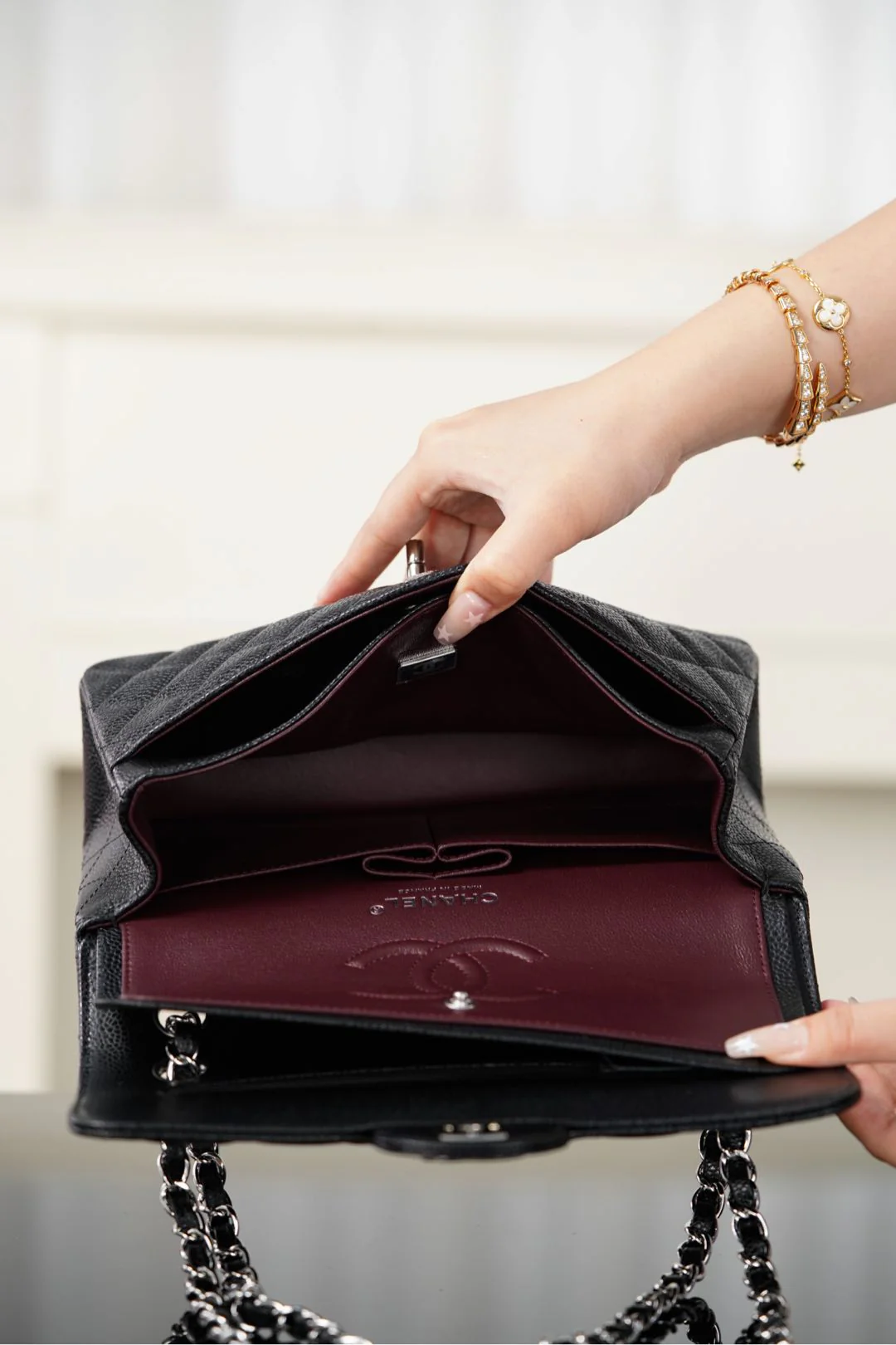 Сумка-гармошка Chanel 25b с двумя ручками в форме буквы С, черная с золотой пряжкой.