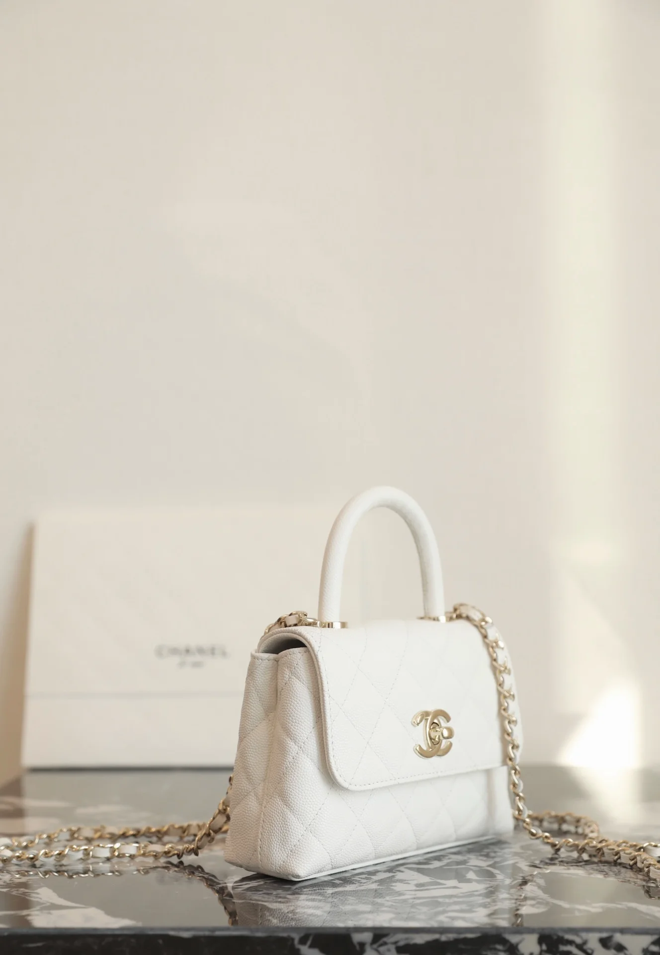 Сумка Chanel с цепочкой и клапаном — белая с фурнитурой из светлого золота.