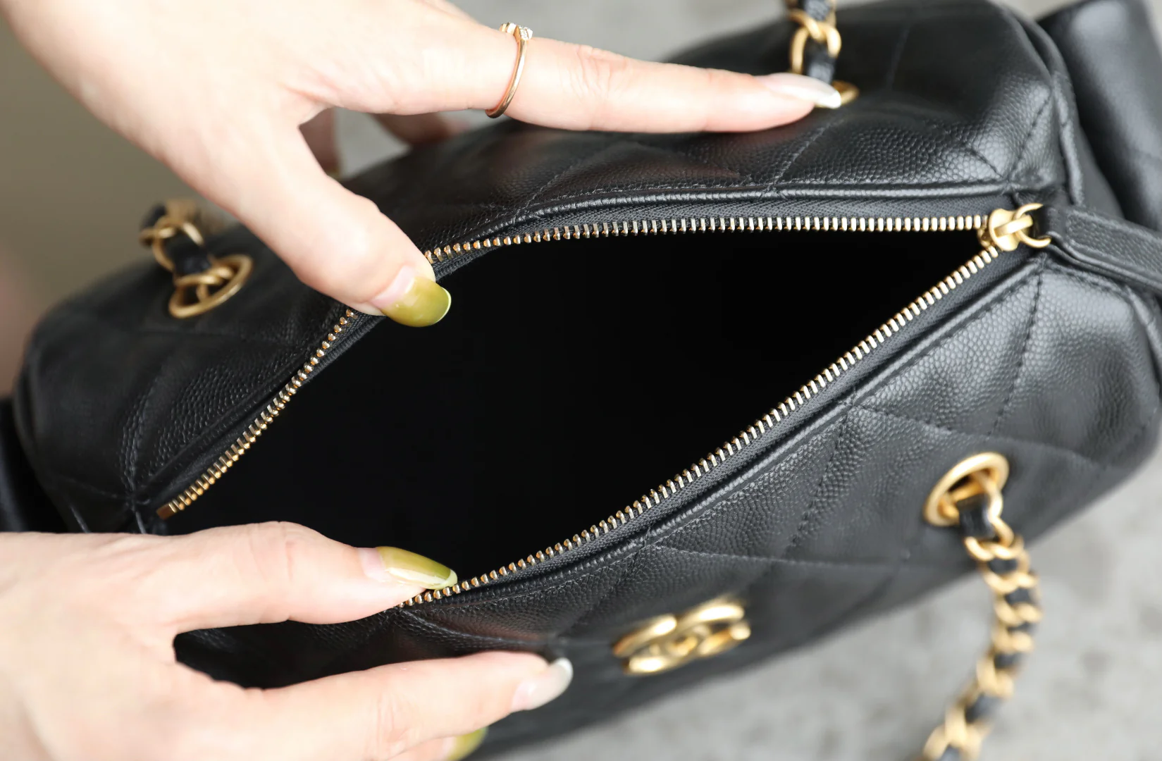 Сумка-боулинг Chanel 25k с двумя карманами — черная кожа с золотой пряжкой и маленьким шариком.