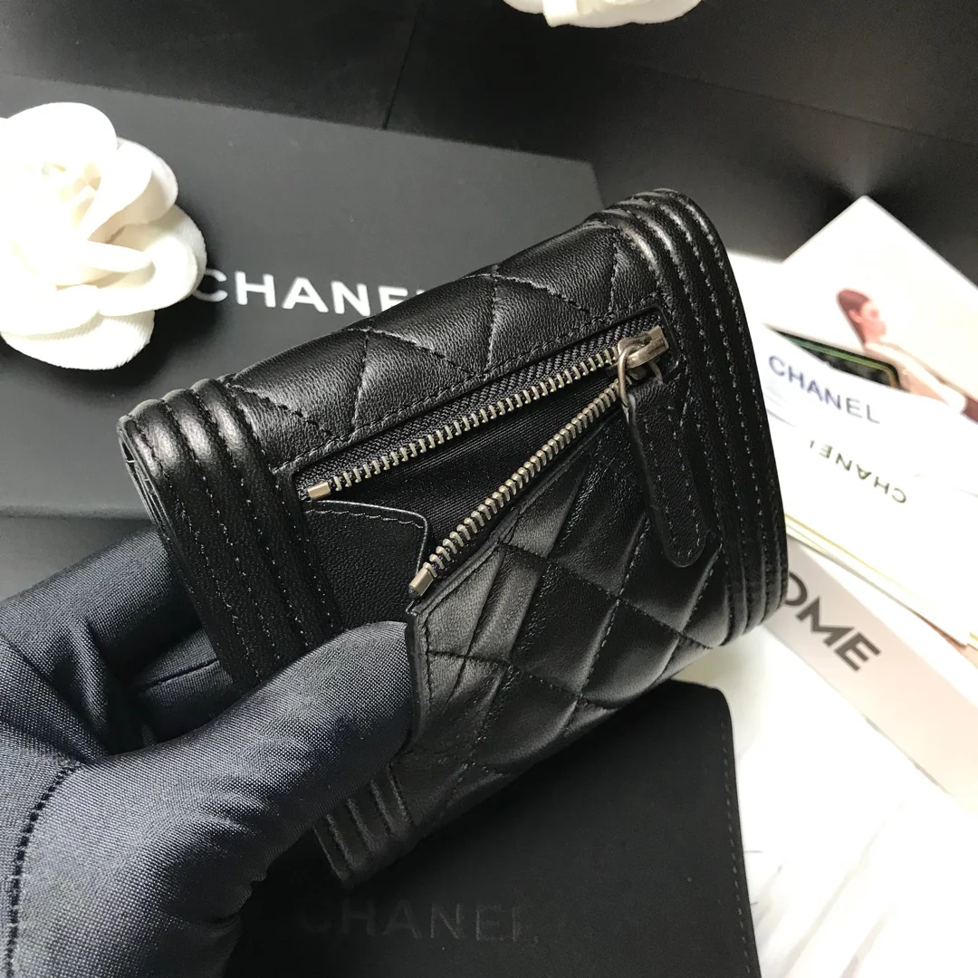 Кошелек Chanel Le Boy Tri-fold Wallet — из черной овечьей кожи с серебряной пряжкой.