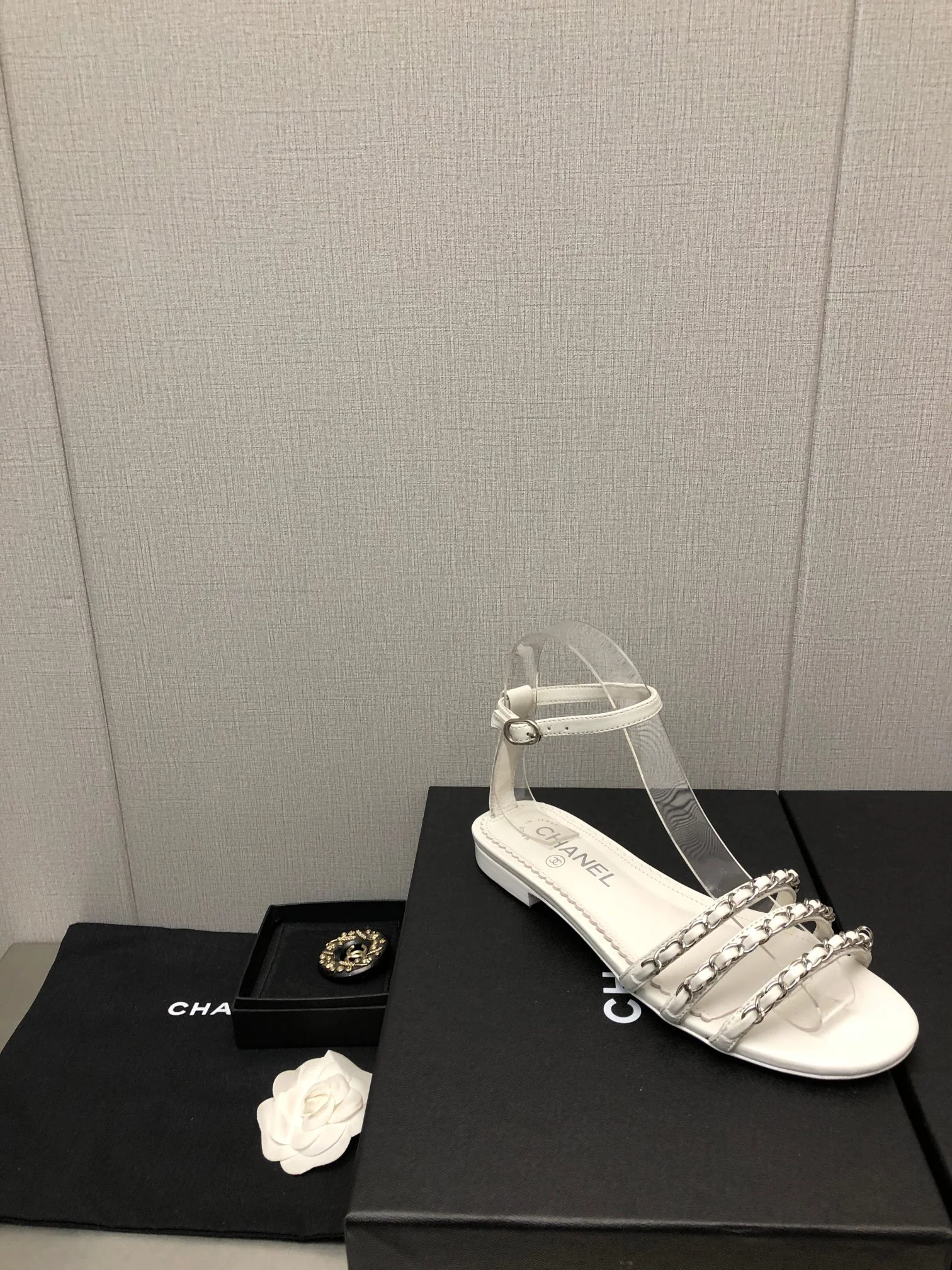 Новинка весны 2023 года от Chanel - сандалии на плоской подошве с цепочкой - белые.