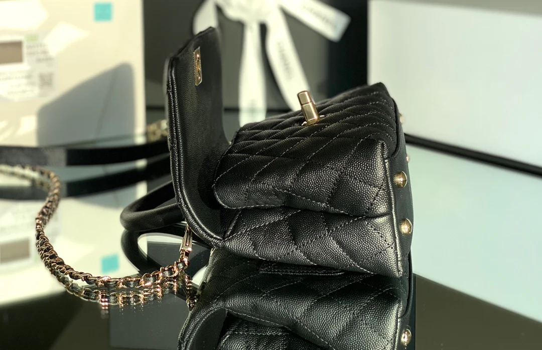 Мини-сумка Chanel Coco Handle — черная кожа с золотистой пряжкой.