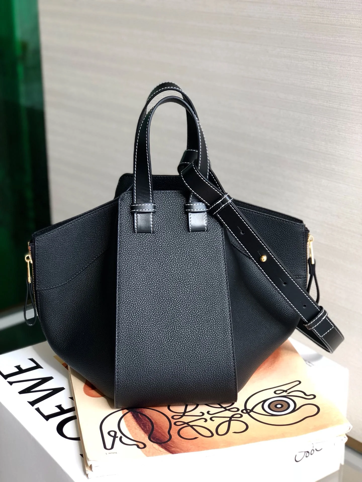 Гамак Loewe, маленький (13,5 x 25 x 30 см), черный с фактурной поверхностью и золотистой фурнитурой.