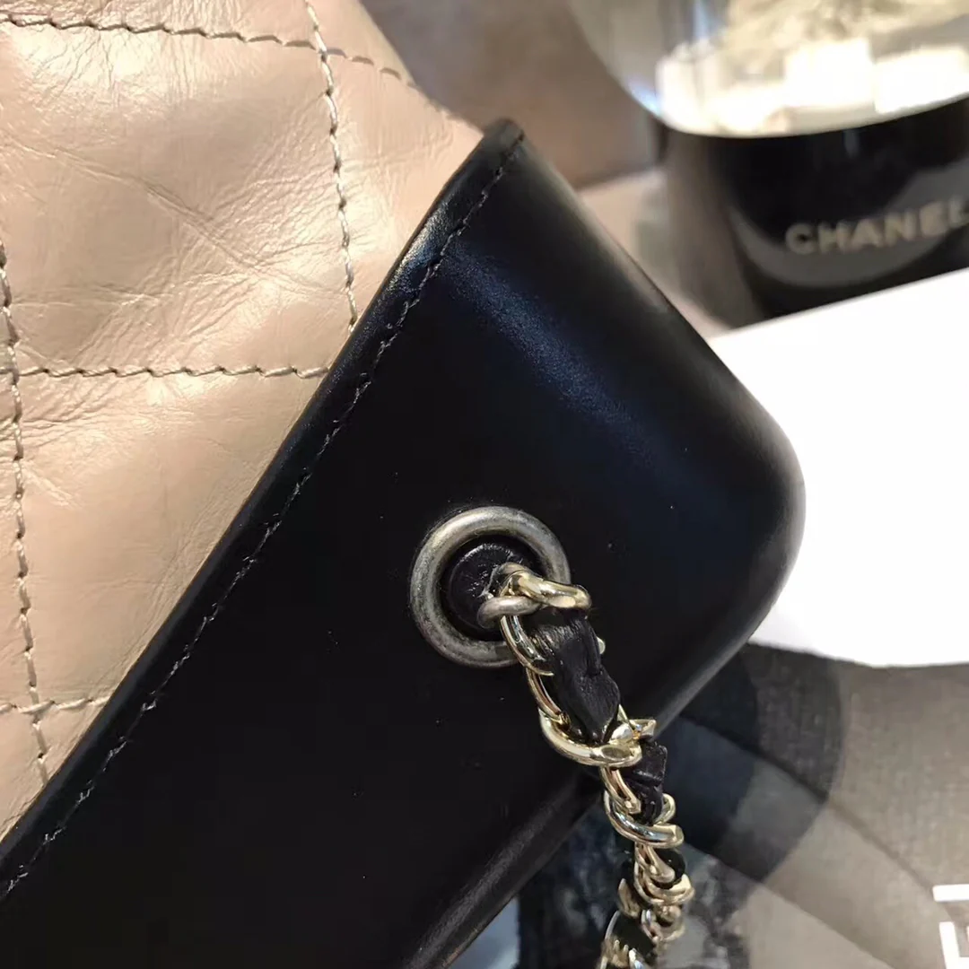 Маленький рюкзак-хобо Chanel — бежевый и черный.