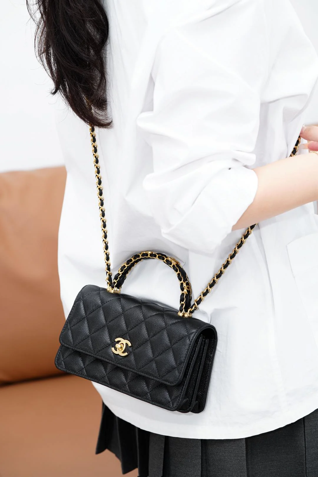 Сумка-гармошка Chanel 25b с двумя ручками в форме буквы С, черная с золотой пряжкой.