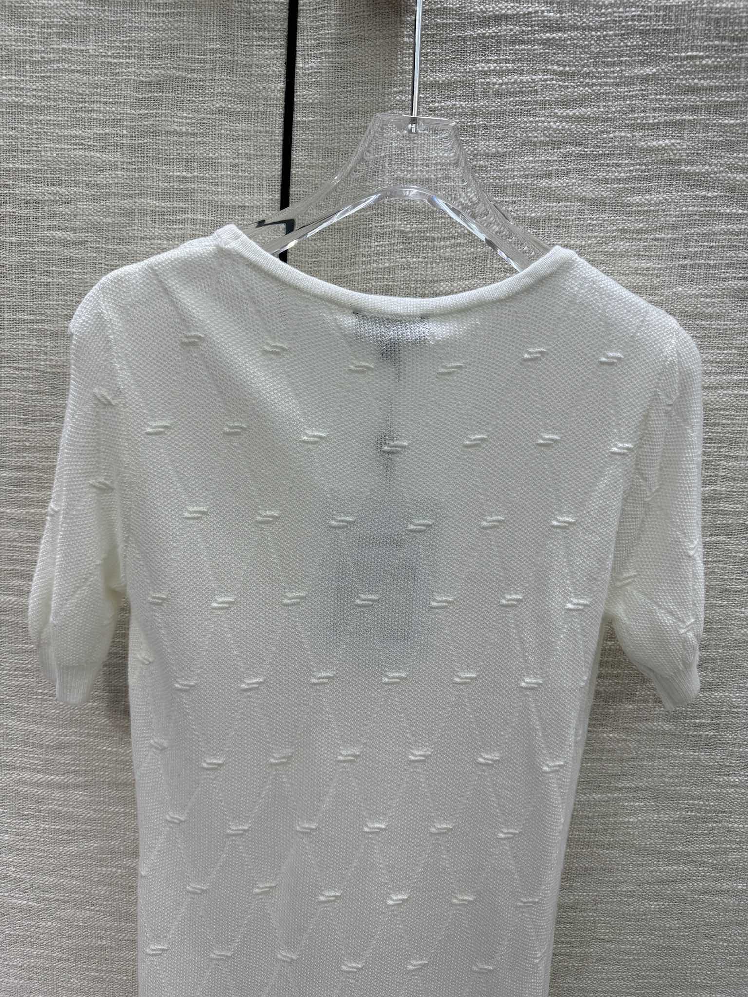 Новая коллекция Chanel Весна/Лето 2024: трикотажное платье с короткими рукавами и ромбовидным узором, белое.