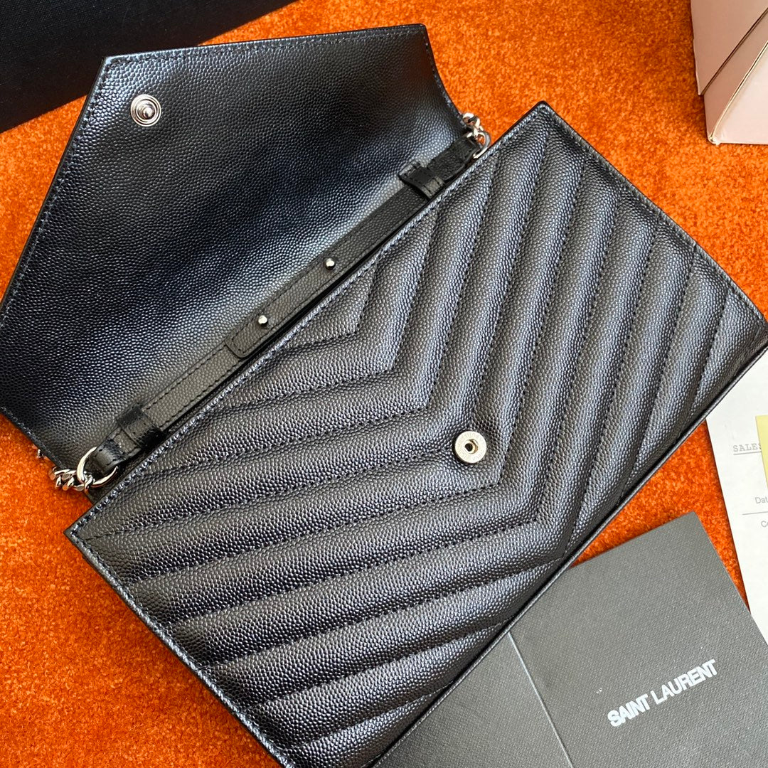 Сумка-конверт YSL с монограммой из икры — черная с серебристой фурнитурой.