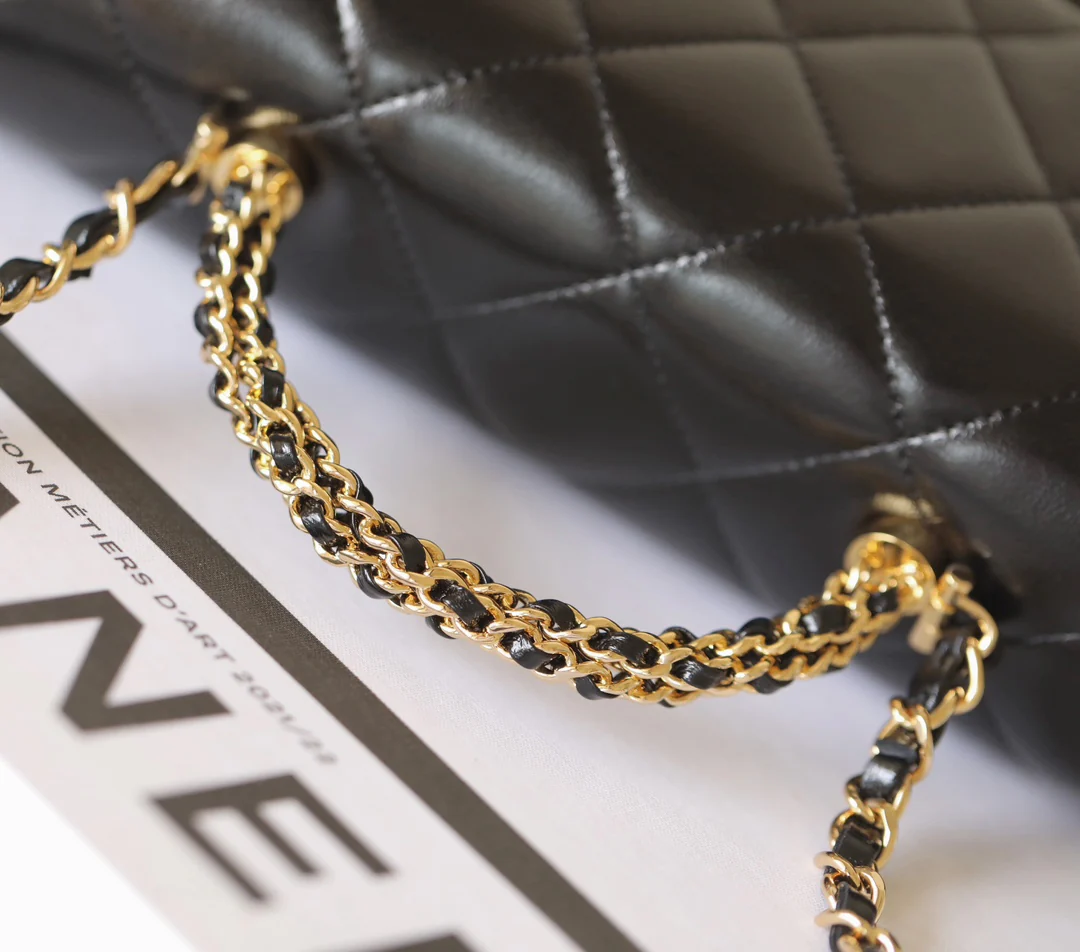 Большая черная сумка Chanel с клапаном и поворотной ручкой.