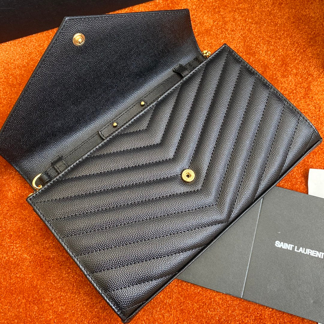 Сумка-конверт YSL с монограммой из икры — черная с золотой фурнитурой.