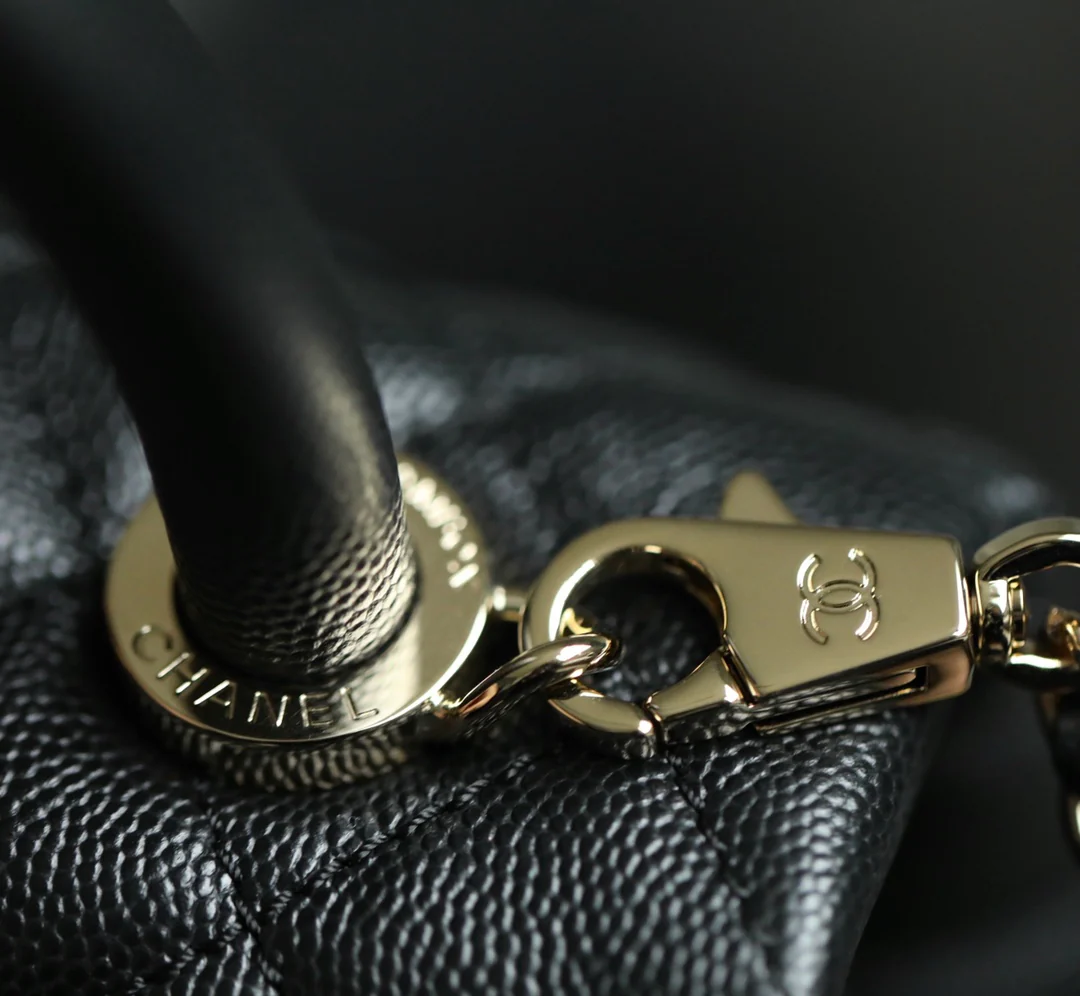 Мини-сумка Chanel Coco Handle — черная кожа с золотистой пряжкой.