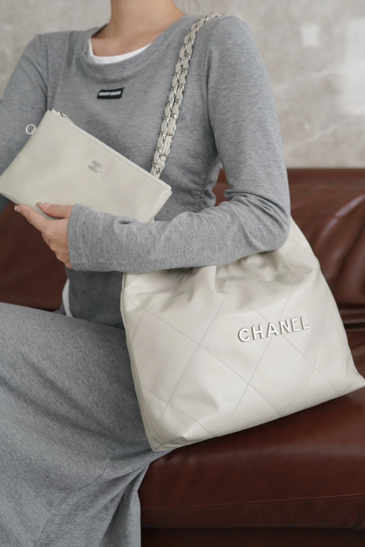 Маленькая белая сумочка Chanel с серебряной пряжкой на задней части.