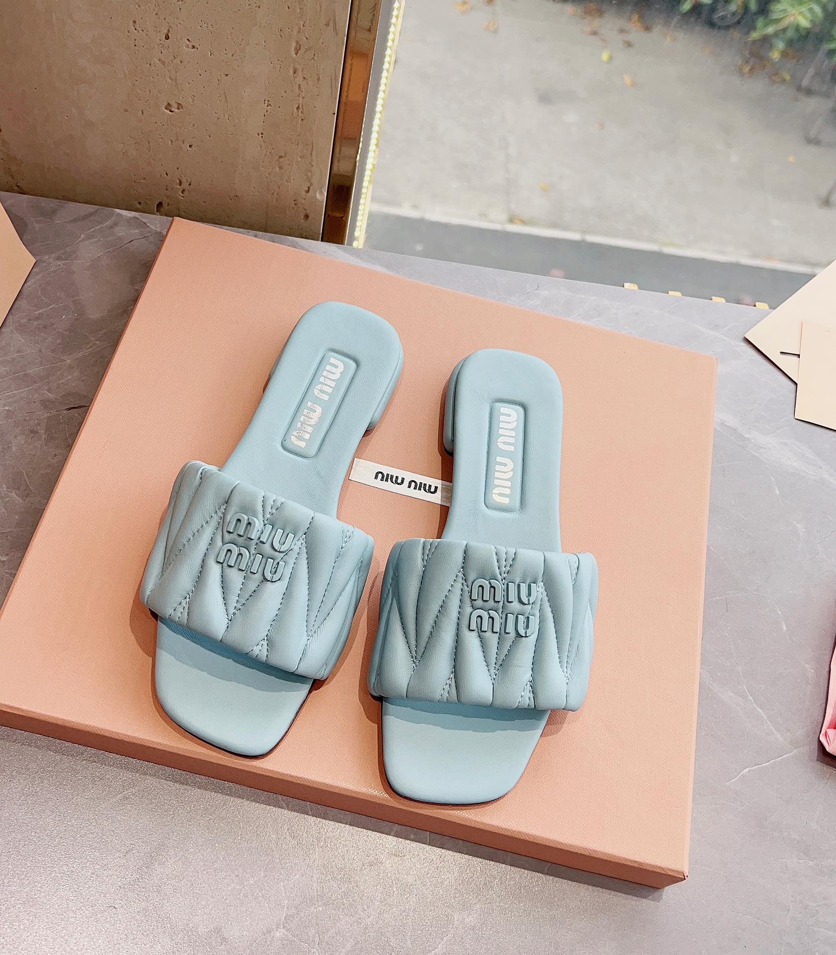 Новинка сезона весна/лето 2023 от Miu Miu - плоские тапочки из овечьей кожи - светло-серые.