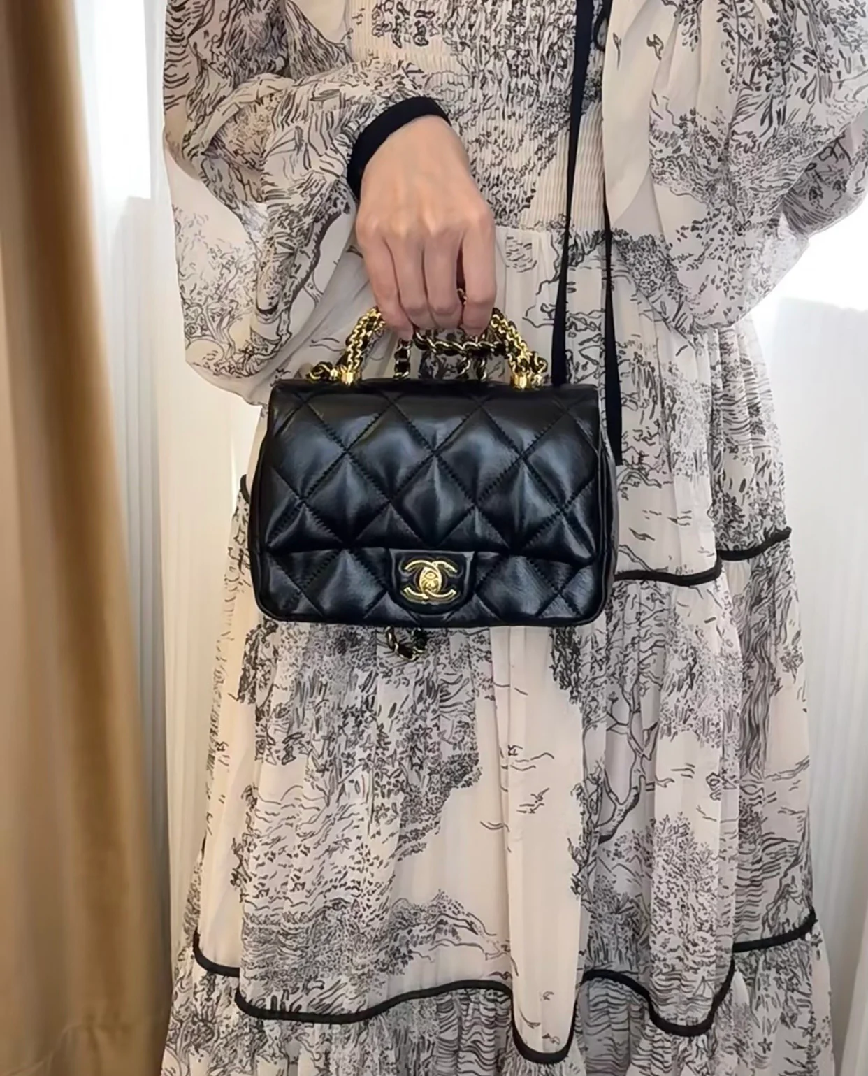 Маленькая черная сумка Chanel с клапаном и поворотной ручкой.
