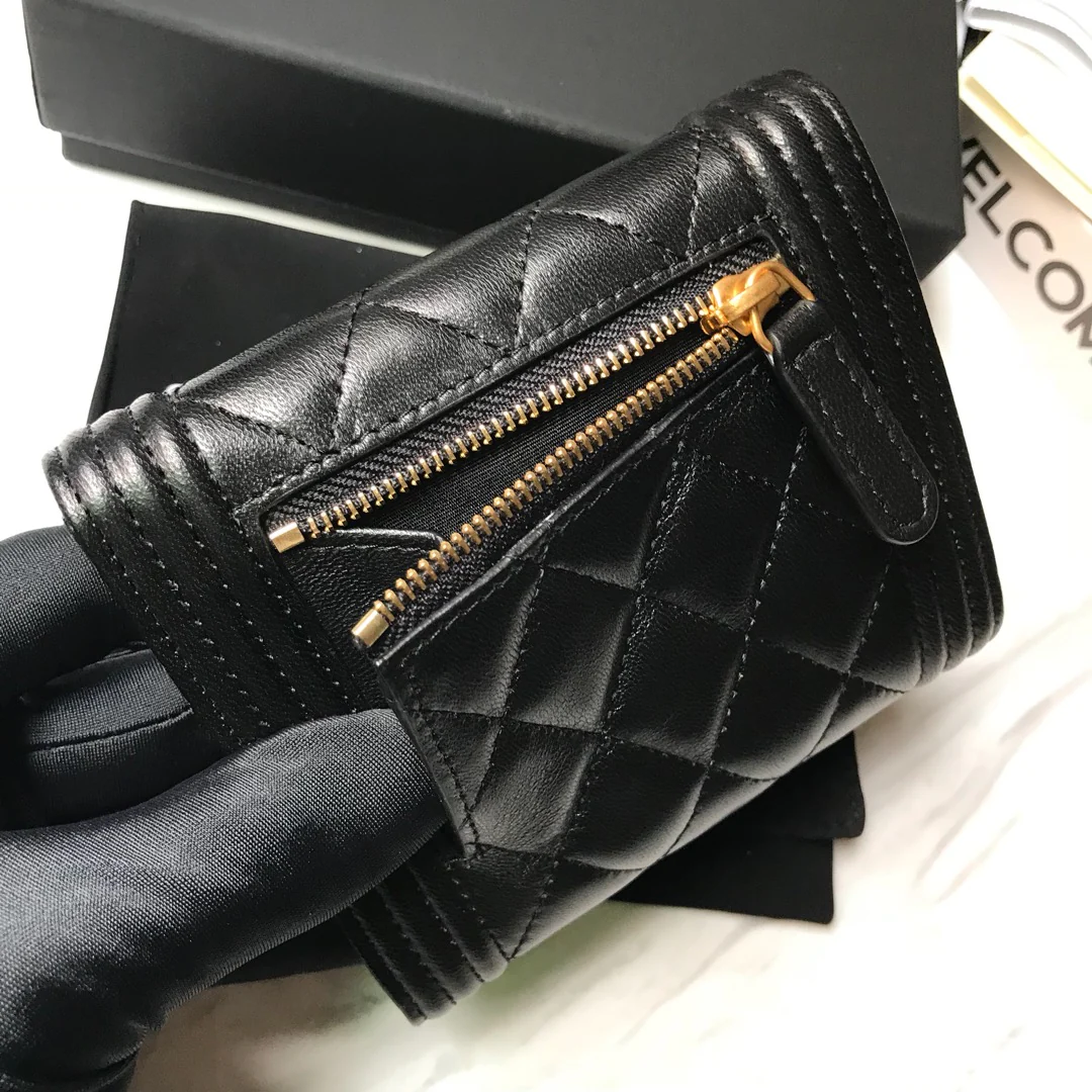 Кошелек Chanel Le Boy Tri-fold Wallet — из черной овечьей кожи с золотой пряжкой.