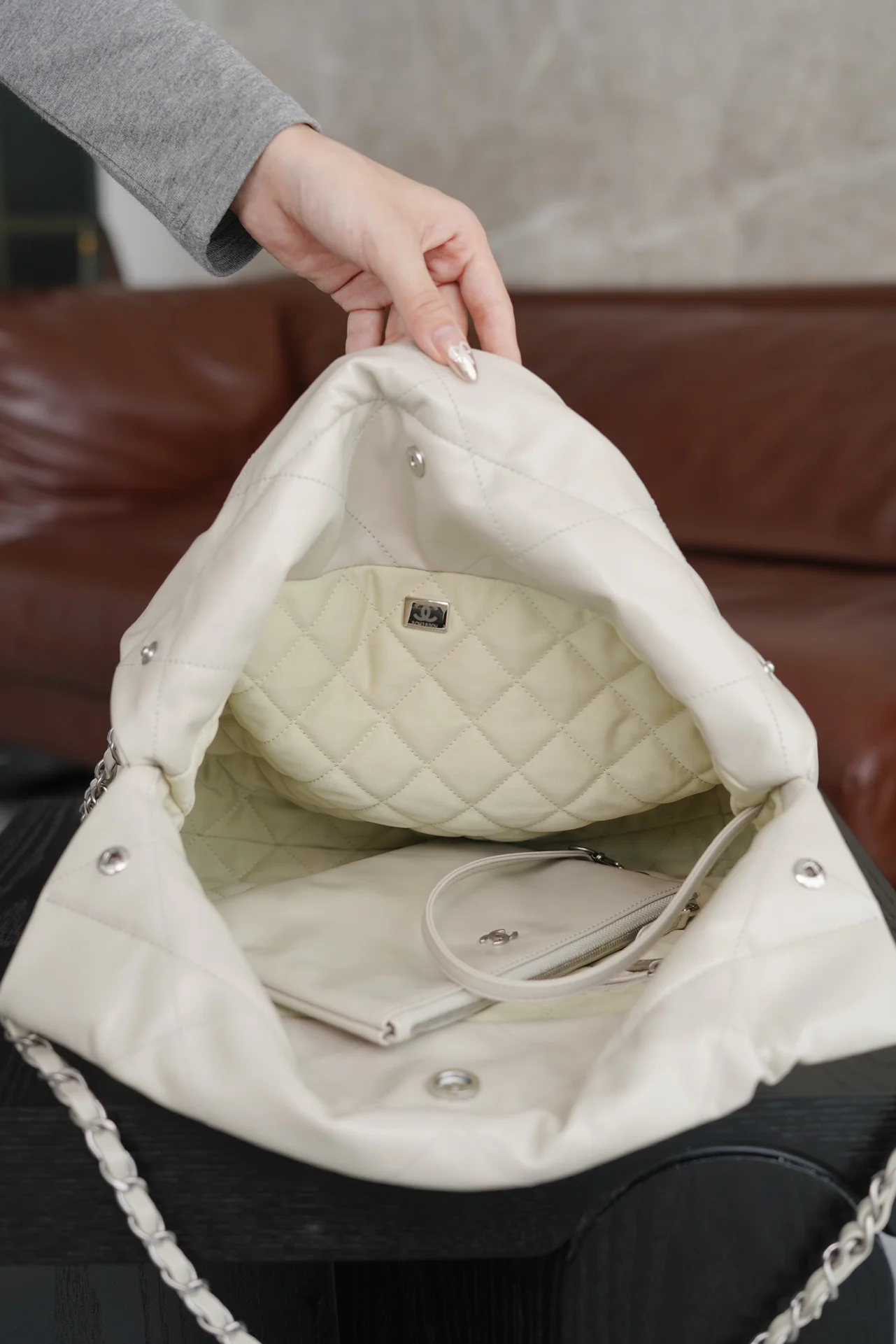 Маленькая белая сумочка Chanel с серебряной пряжкой на задней части.