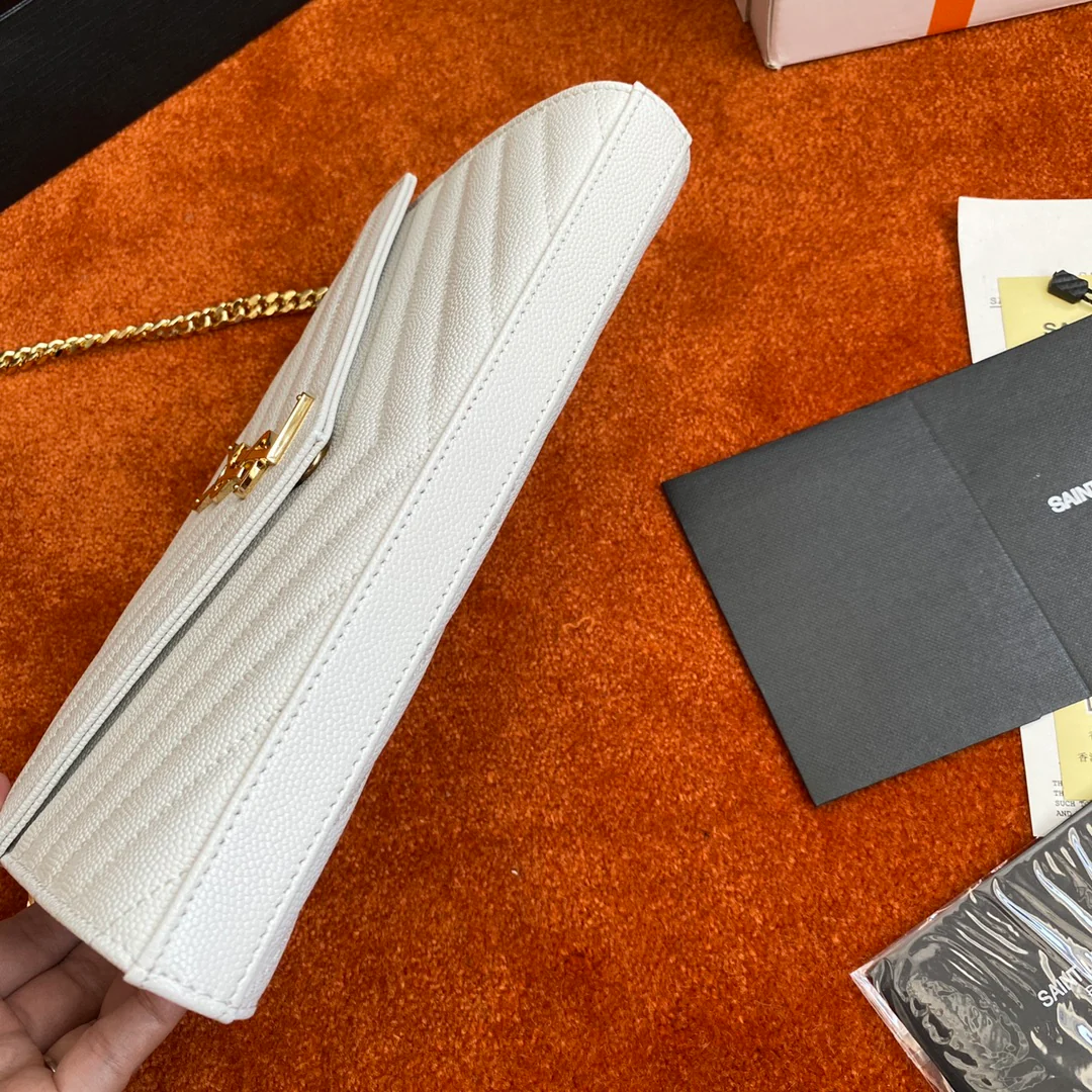 Сумочка-конверт YSL с монограммой из икры — белая с золотой фурнитурой.