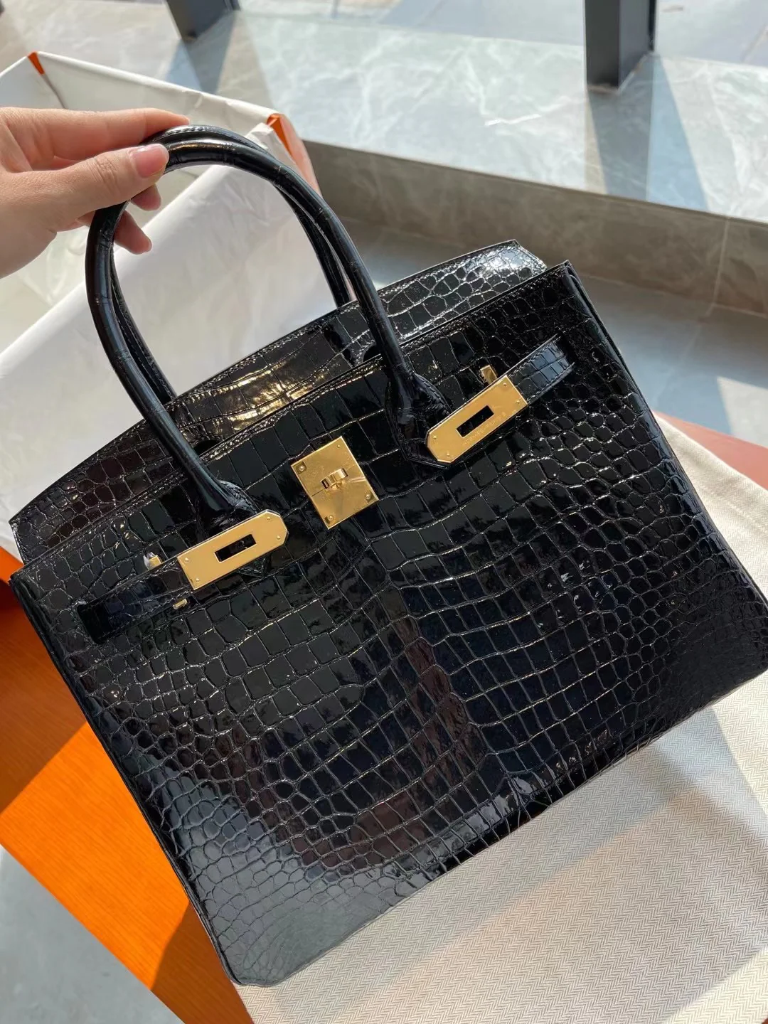 Сумка Hermes Birkin 30 из кожи аллигатора, черная, с золотой пряжкой.