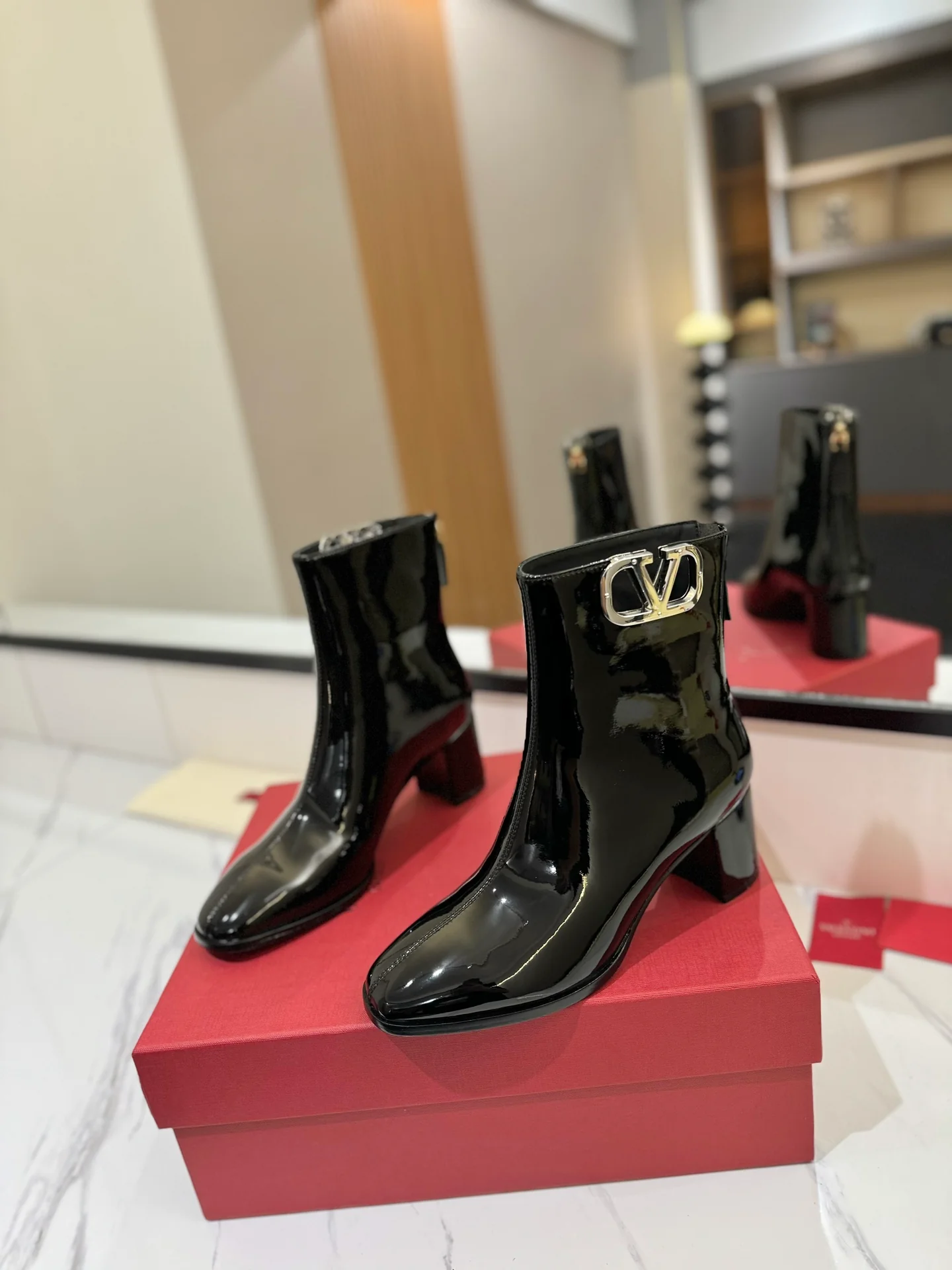 Ботильоны на высоком каблуке из лакированной кожи Valentino 2024 года — черные.