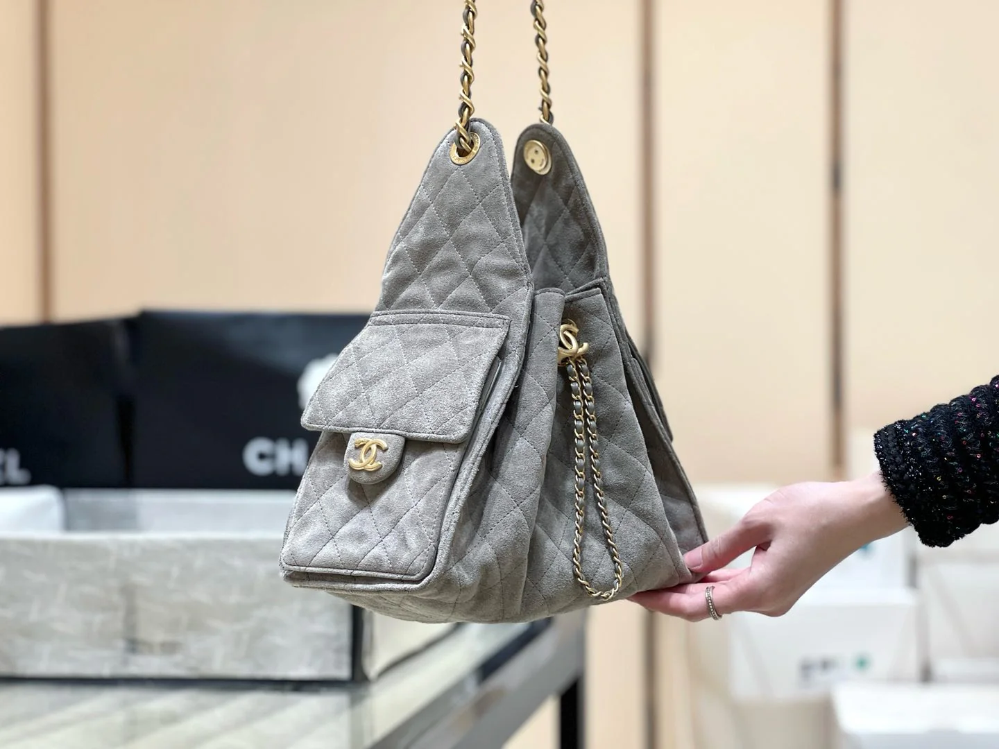 Популярная сумка-хобо Chanel 25c, которую можно носить под мышкой — серо-коричневая.