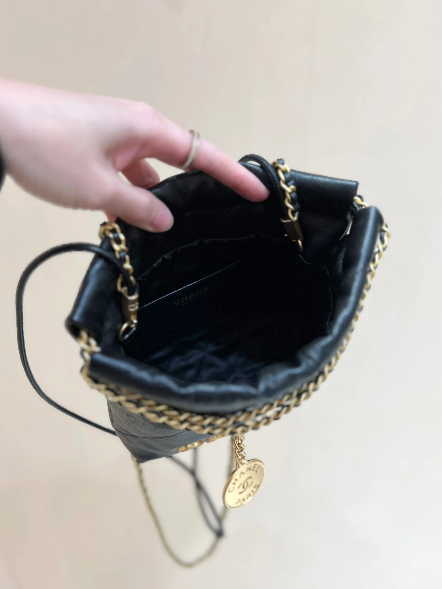 Мини-сумочка Chanel 22 из 24-каратного золота с текстурой зернистой кожи — черная.