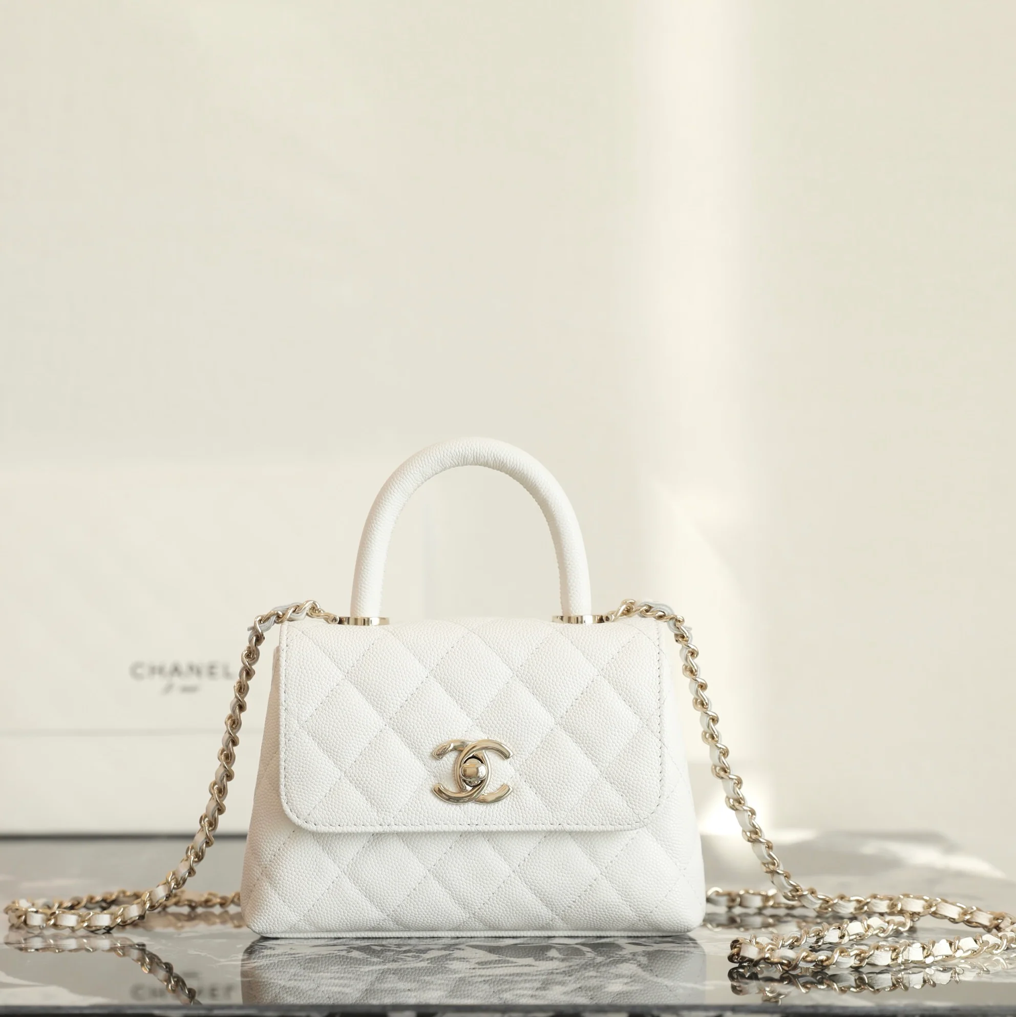 Сумка Chanel с цепочкой и клапаном — белая с фурнитурой из светлого золота.