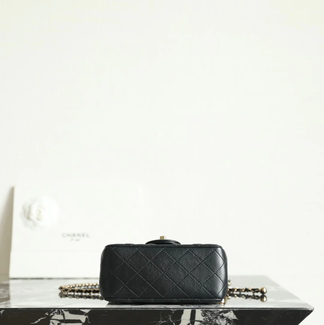 Сумка-шар Chanel из 25-каратного золота с регулируемой застежкой, черная с фурнитурой из светлого золота.