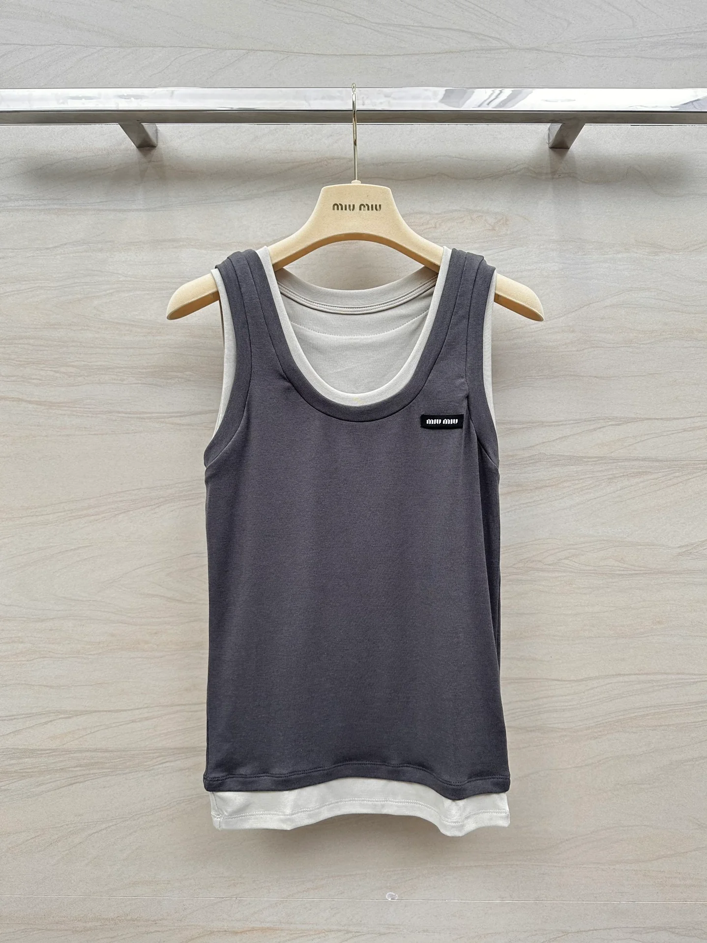 Новинка сезона весна/лето 2024 от Miu Miu: многослойный, культовый универсальный жилет — серый.