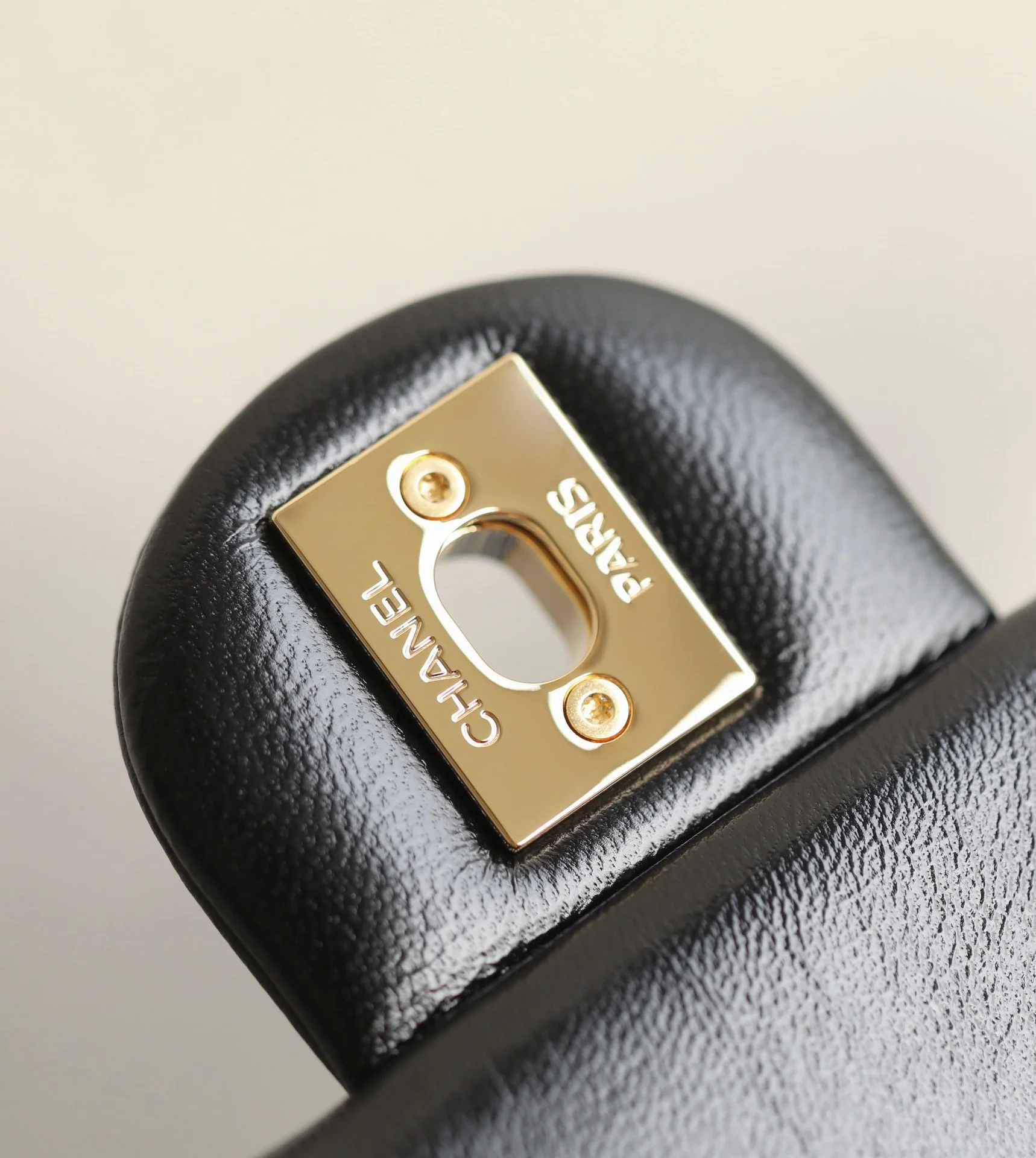 Маленькая черная сумка Chanel с клапаном и поворотной ручкой.