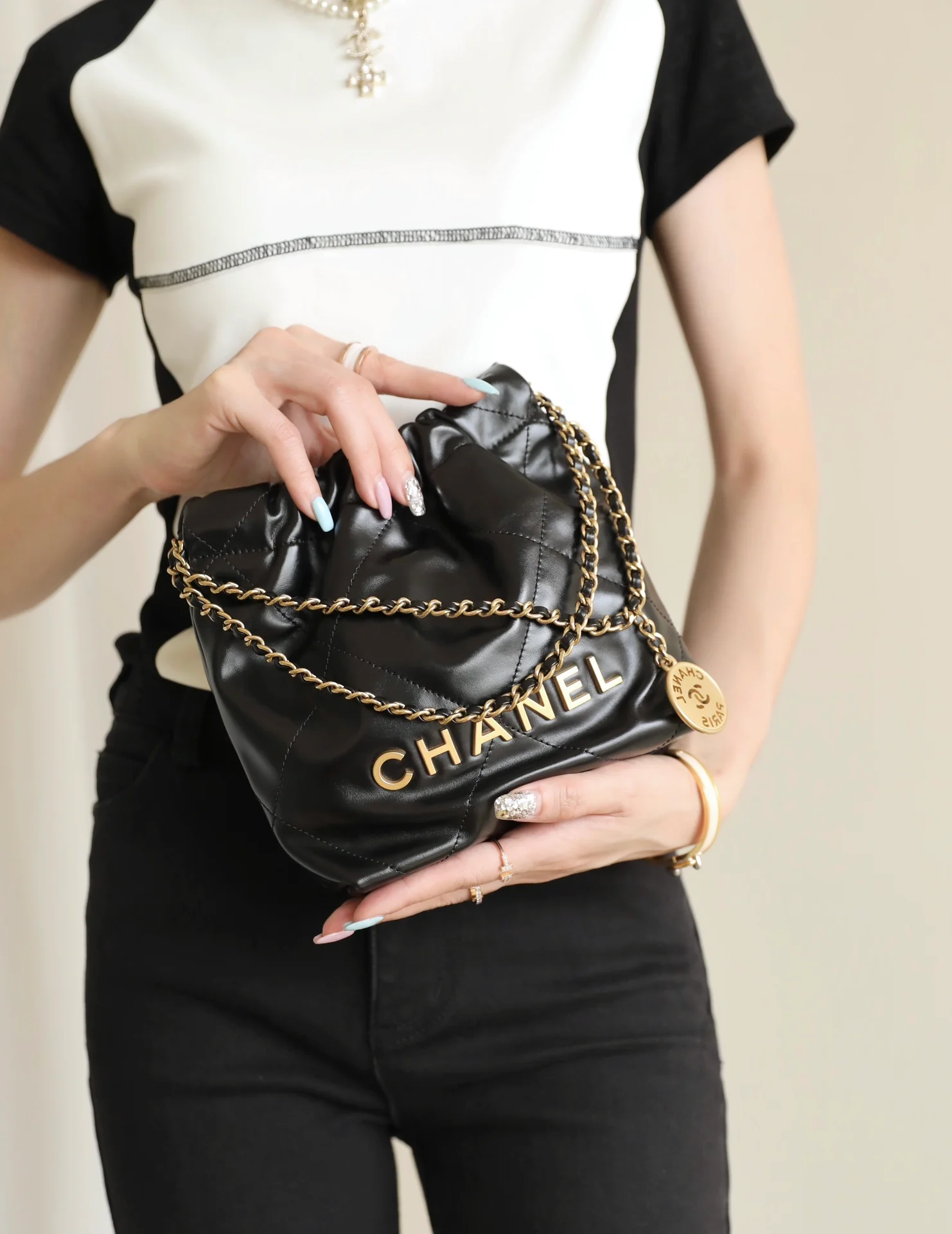 Мини-сумочка Chanel 22 – черная с золотой фурнитурой.