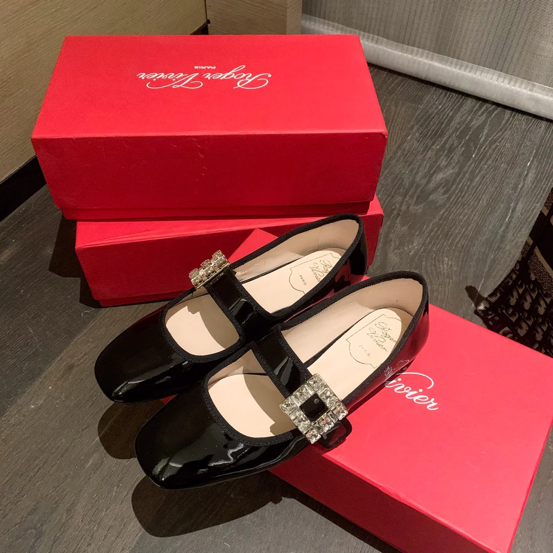 Лакированные балетки с пряжками, украшенными стразами — черные.