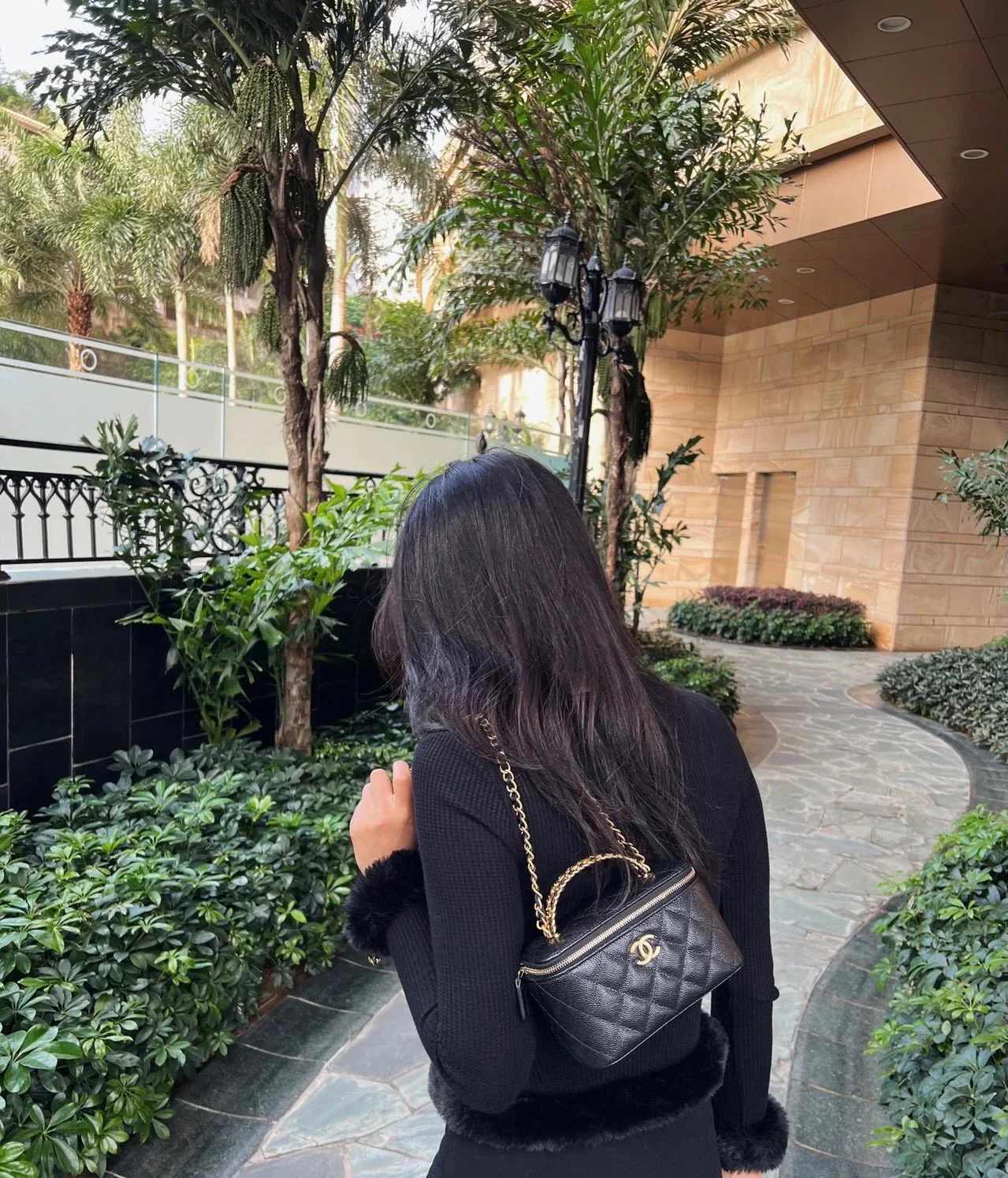 Длинная сумка-коробка Chanel из весенне-летней коллекции с ажурным логотипом на ручке — черная.