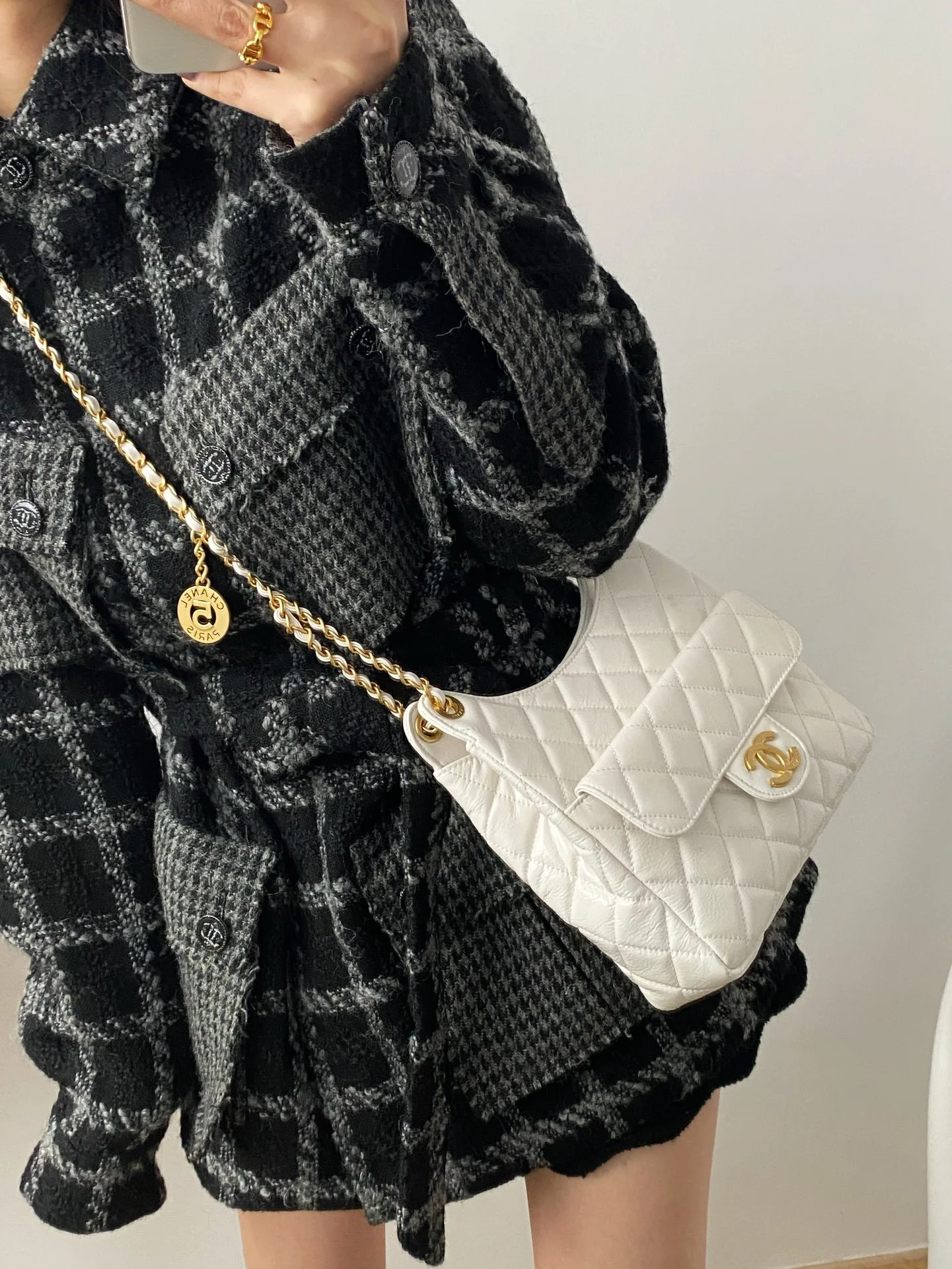 Коллекция Chanel ?Ранняя весна 2023? — сумка-хобо в стиле хиппи — маленькая — белая — фотографии в одежде.