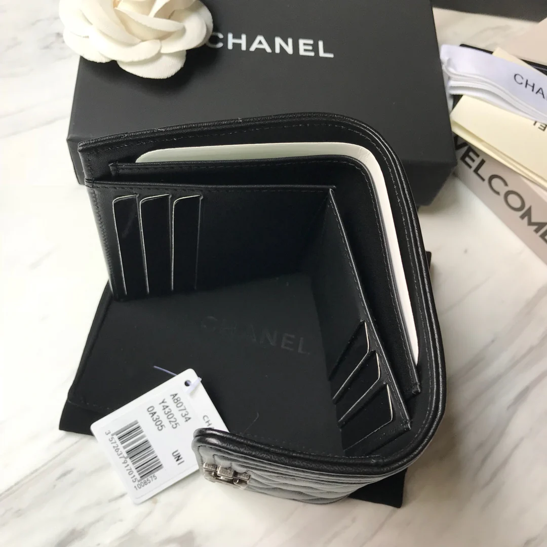 Кошелек Chanel Le Boy Tri-fold Wallet — из черной овечьей кожи с серебряной пряжкой.