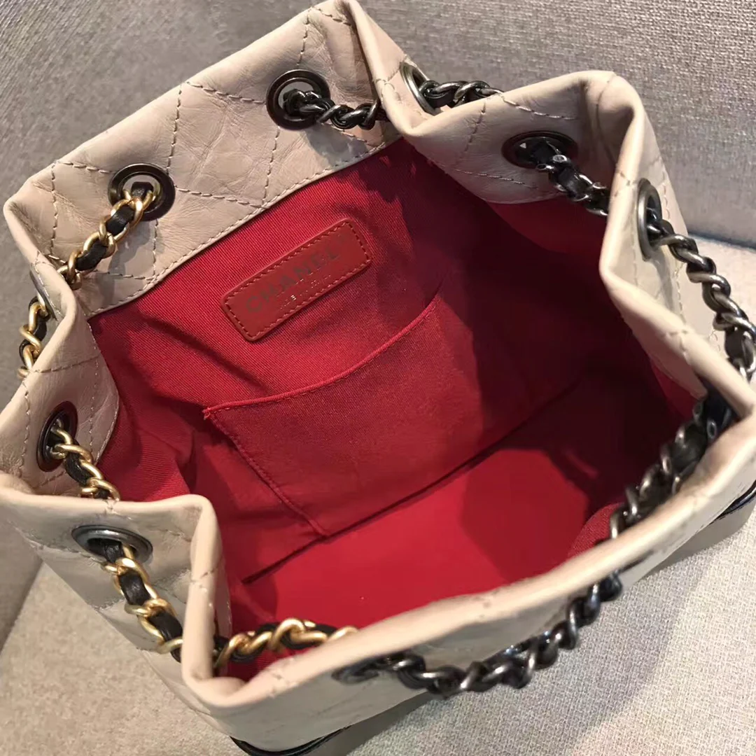 Маленький рюкзак-хобо Chanel — бежевый и черный.