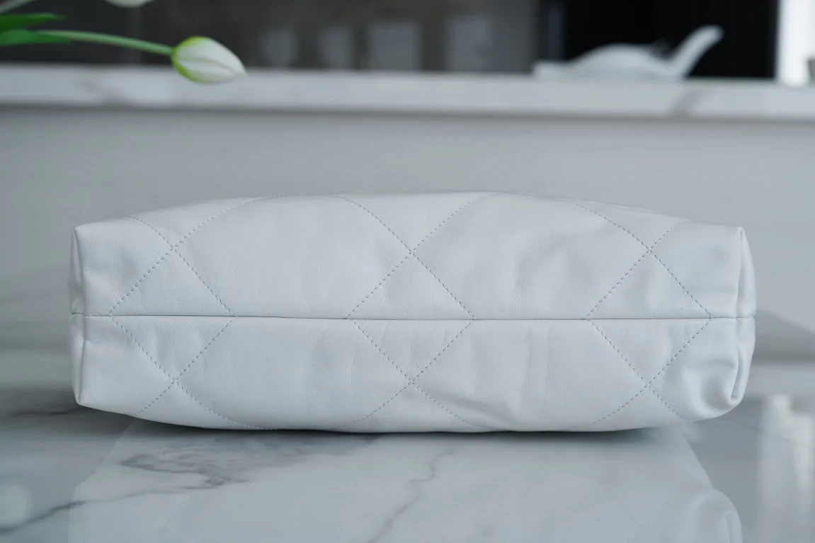 Сумочка Chanel No. 22 — маленькая, белая, серебристая.